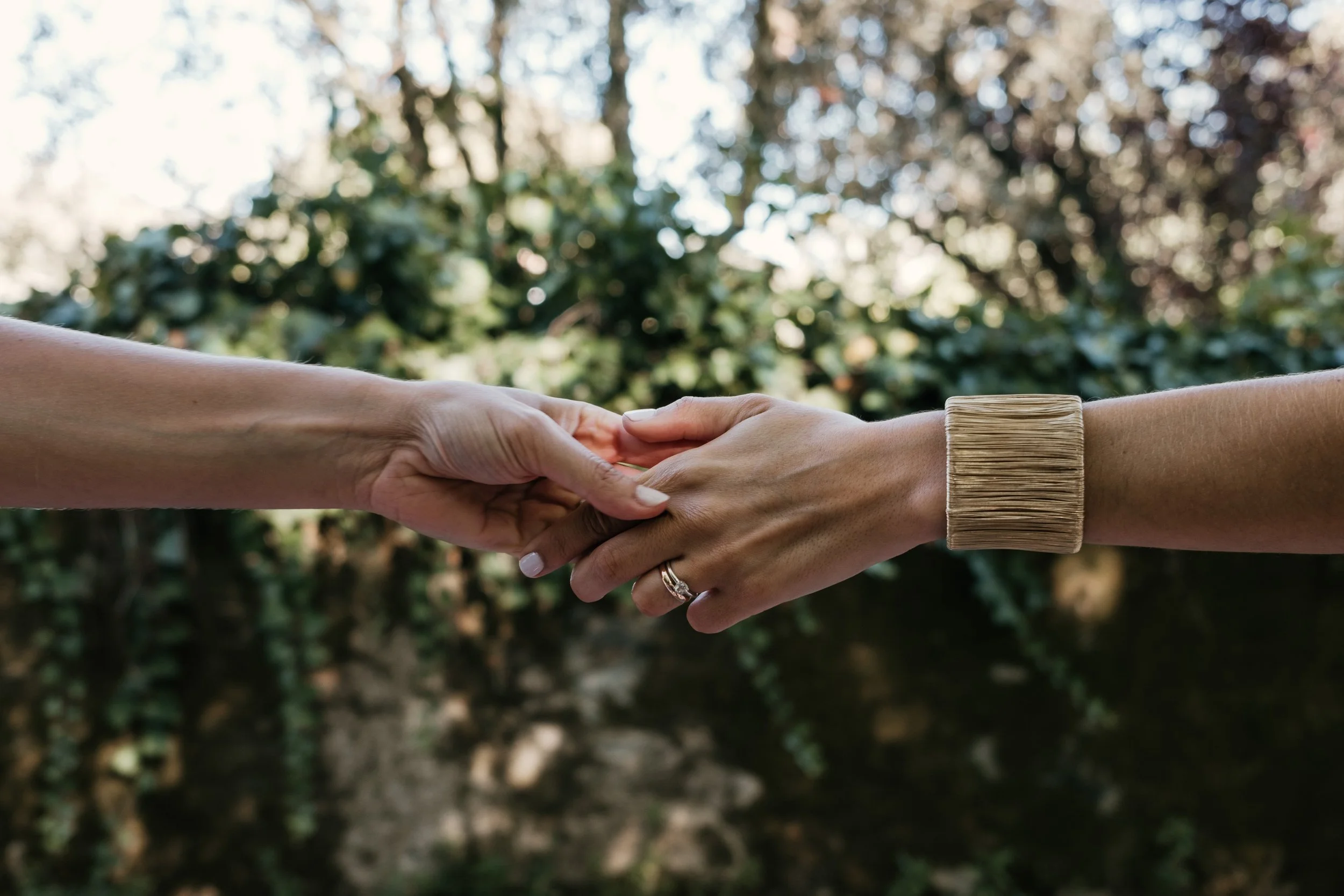 A symbolic moment between Sofia and Leonor, hands meeting in a gesture of love.