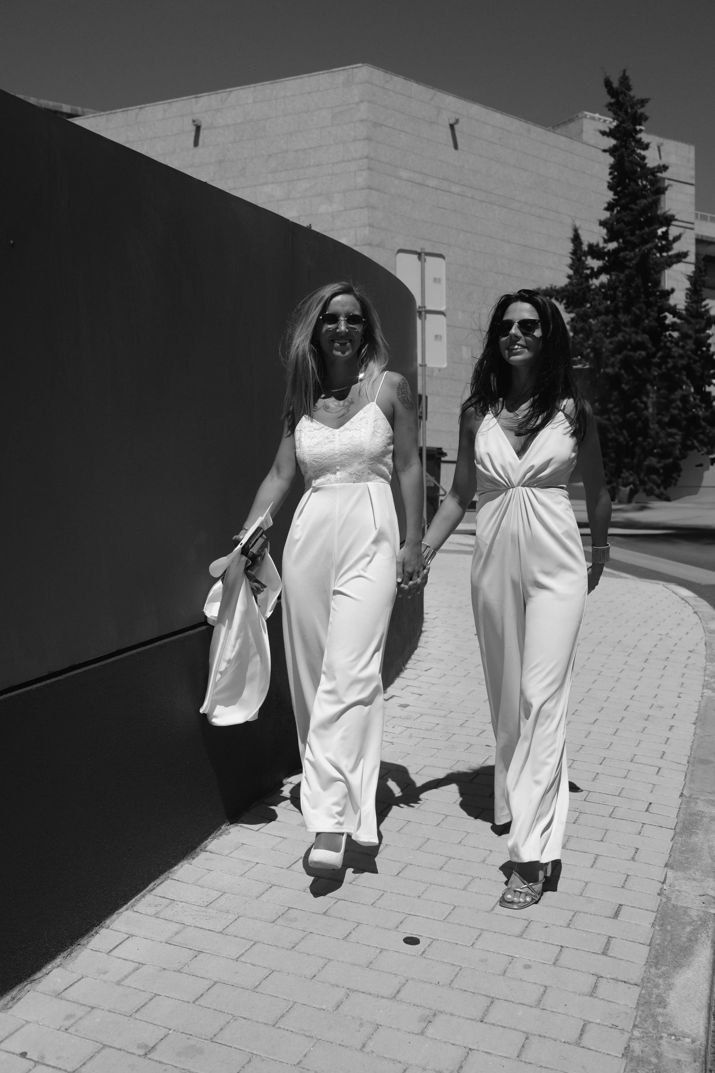 Sofia and Leonor walking hand in hand after their intimate civil ceremony in Cascais.