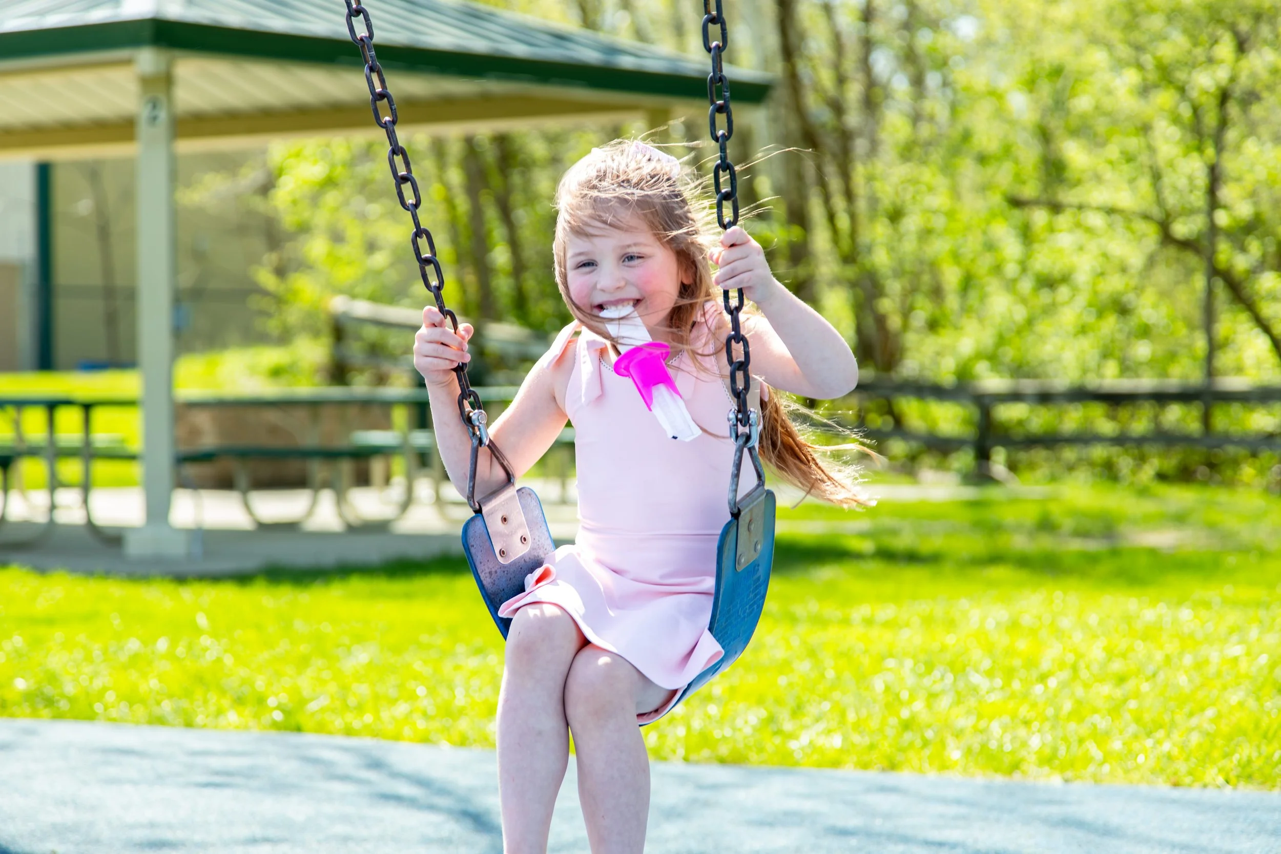 child swinging and eating an ice pop with a pop pal holder