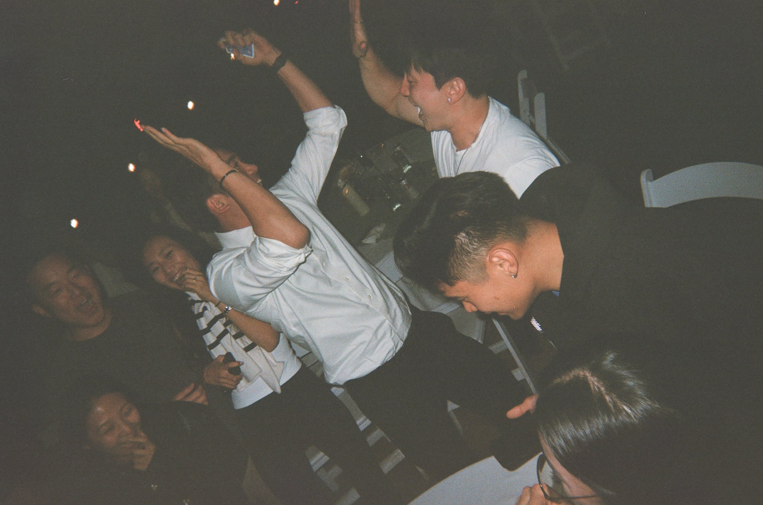 Group of people laughing and enjoying themselves at a social gathering or party.