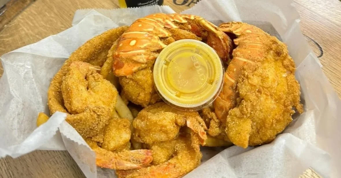 Fried seafood platter with shrimp and fish, served with lemon wedge and dipping sauce