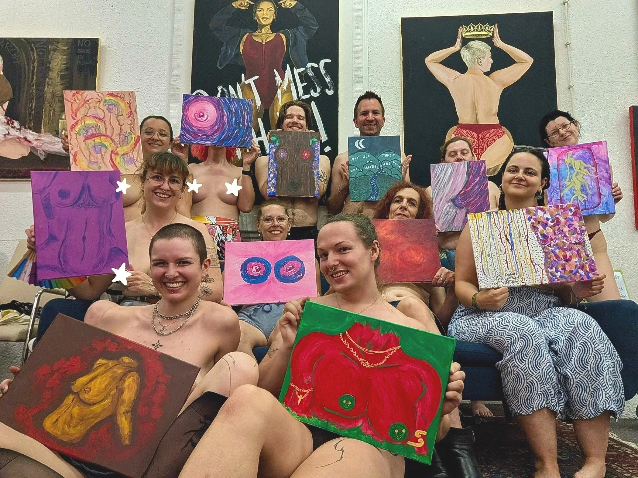 Eine Gruppe von Menschen hält Kunstwerke vor sich, die farbenfrohe, abstrahierte Gemälde zeigen, auf einem Bild im Kunststudio mit Wandkunst im Hintergrund.
