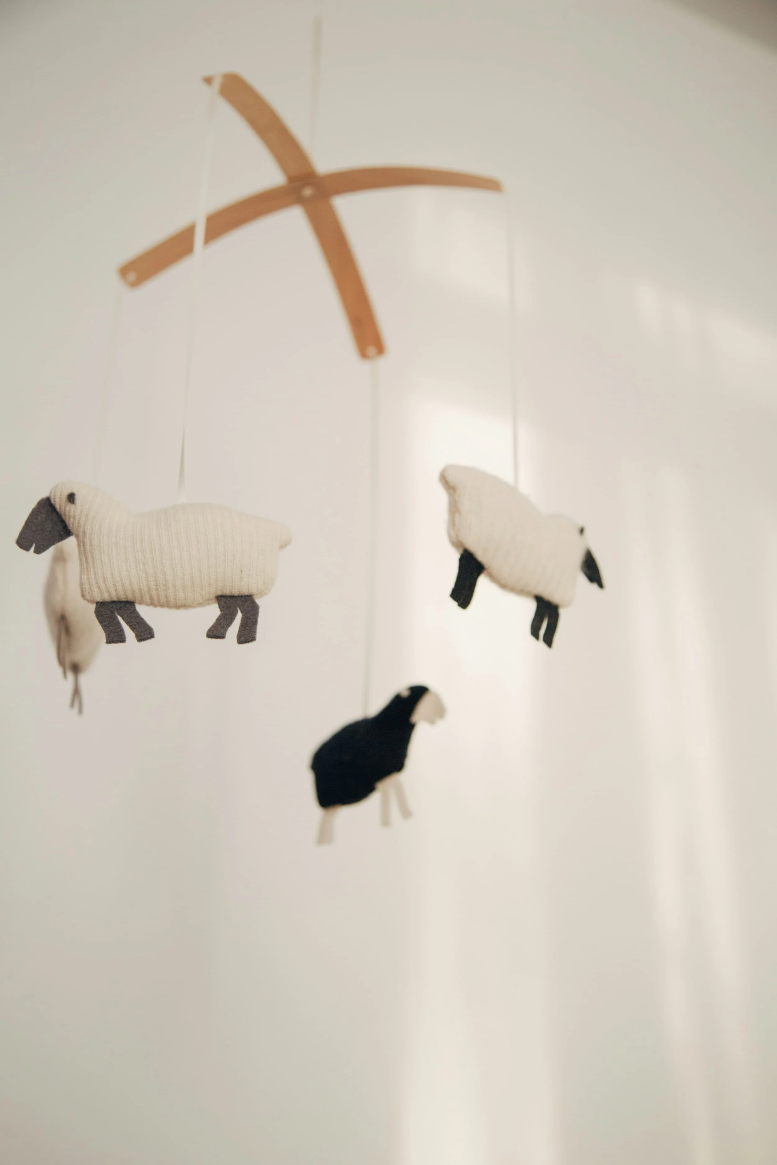 A sheep mobile hangs in a nursery designed with the help of Kirsten Vogt's nursery design support with The Birth Atelier.