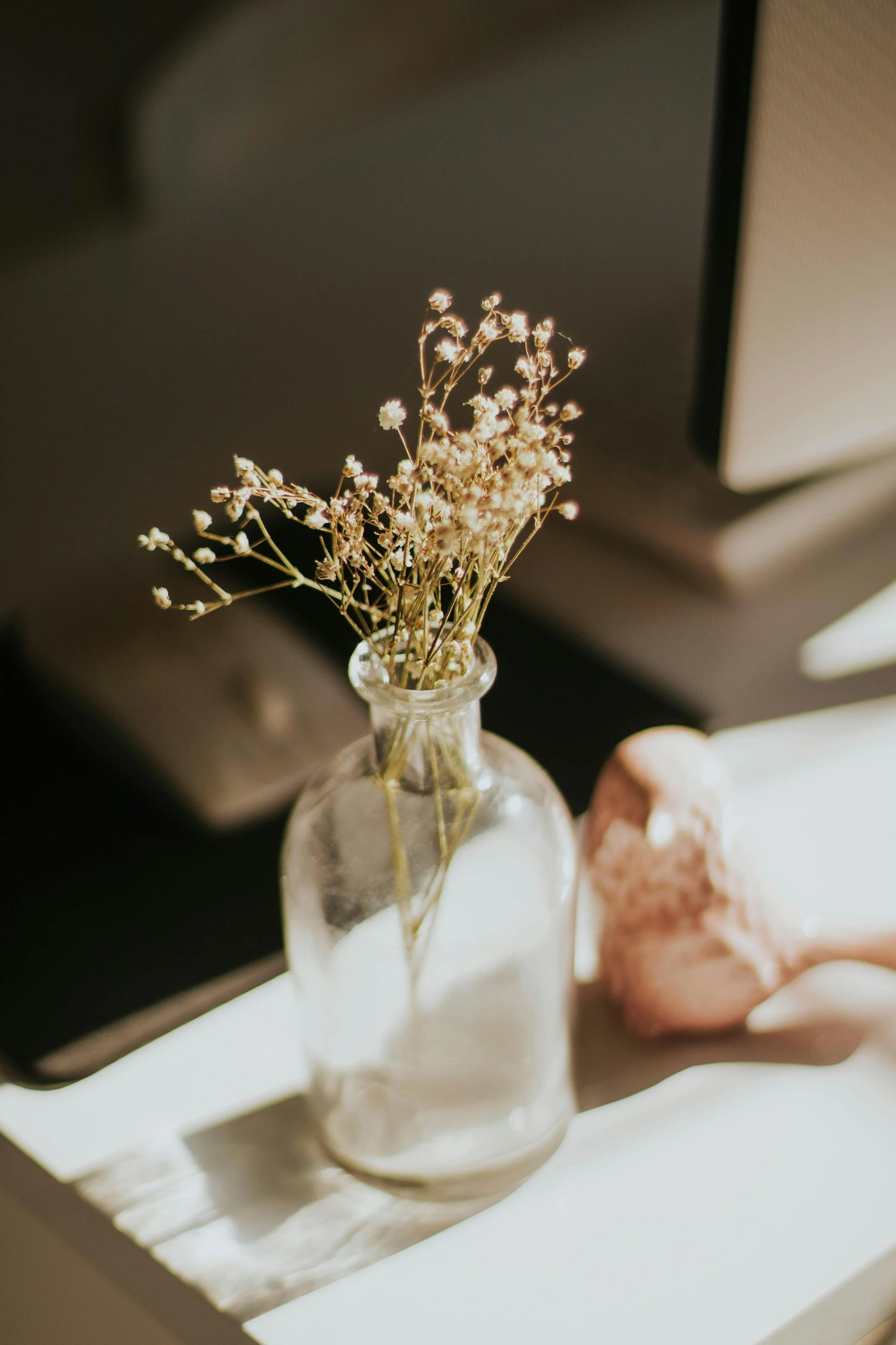 A vase of baby's breath sits in a nursery, designed by Kirsten Vogt with The Birth Atelier in Northern New Jersey.