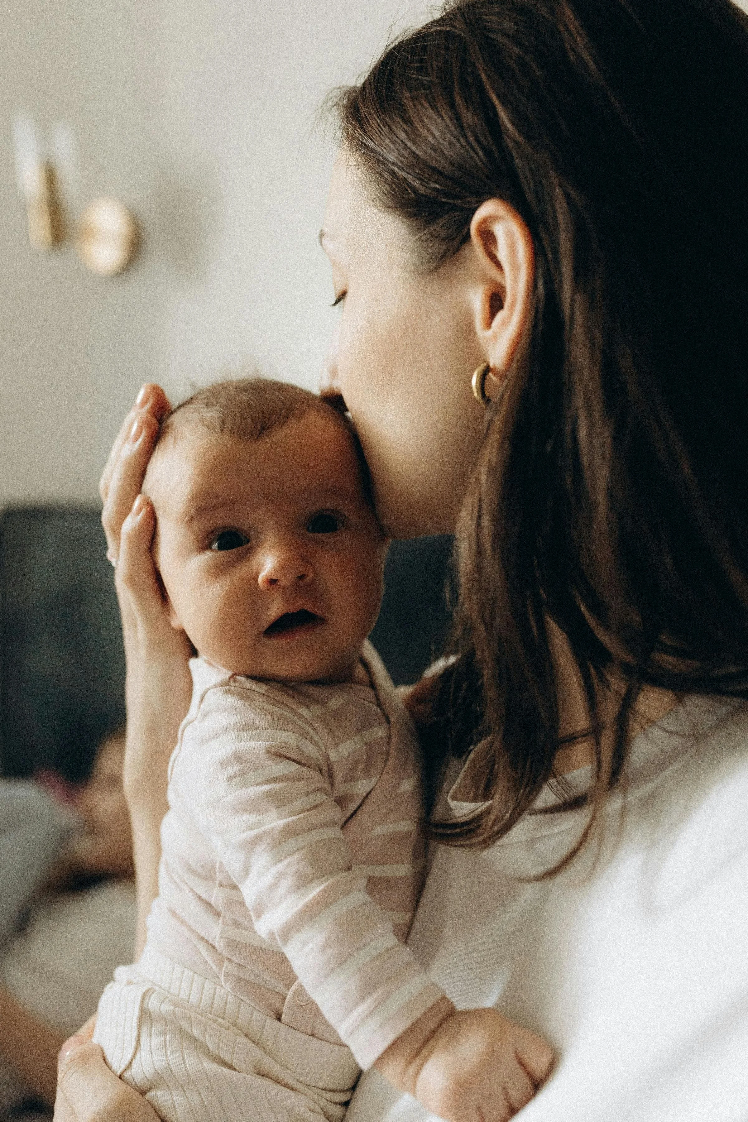 A full spectrum doula from New Jersey holds a newborn while providing daytime postpartum doula support.