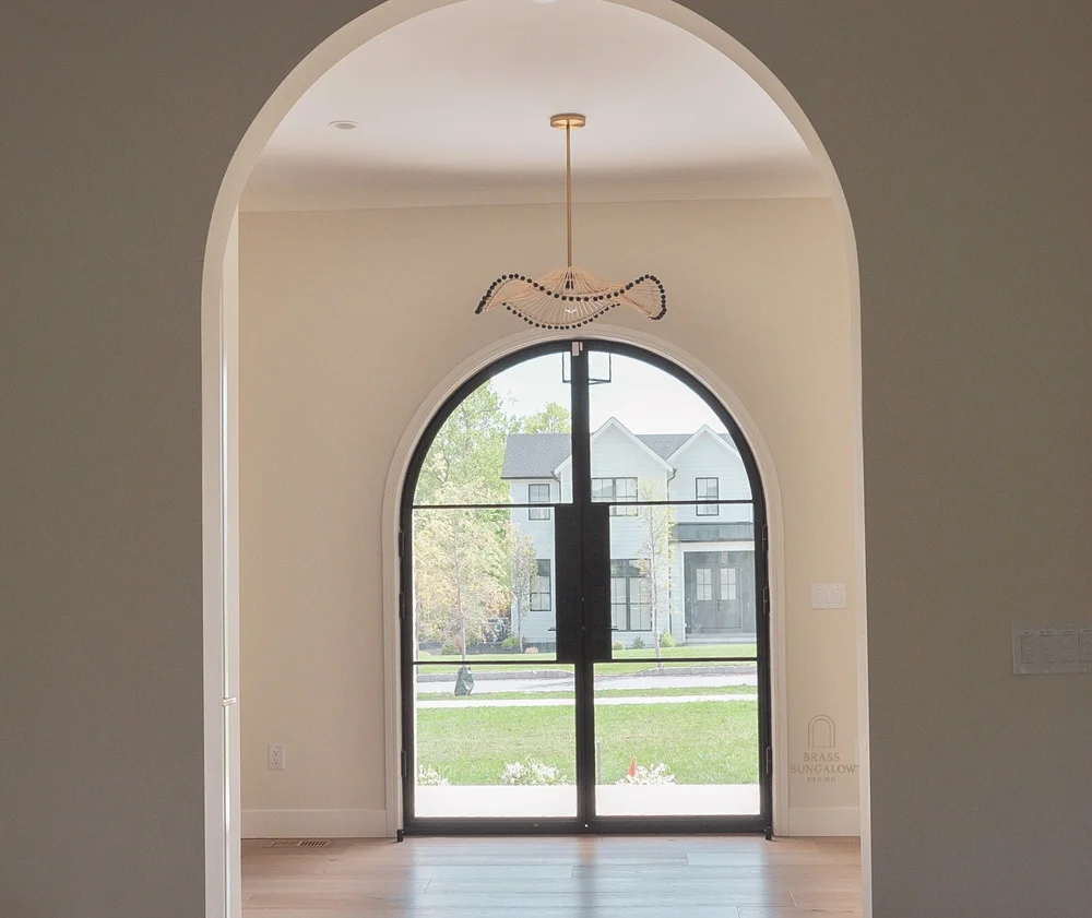 Arched foyer with sculptural pendant lighting