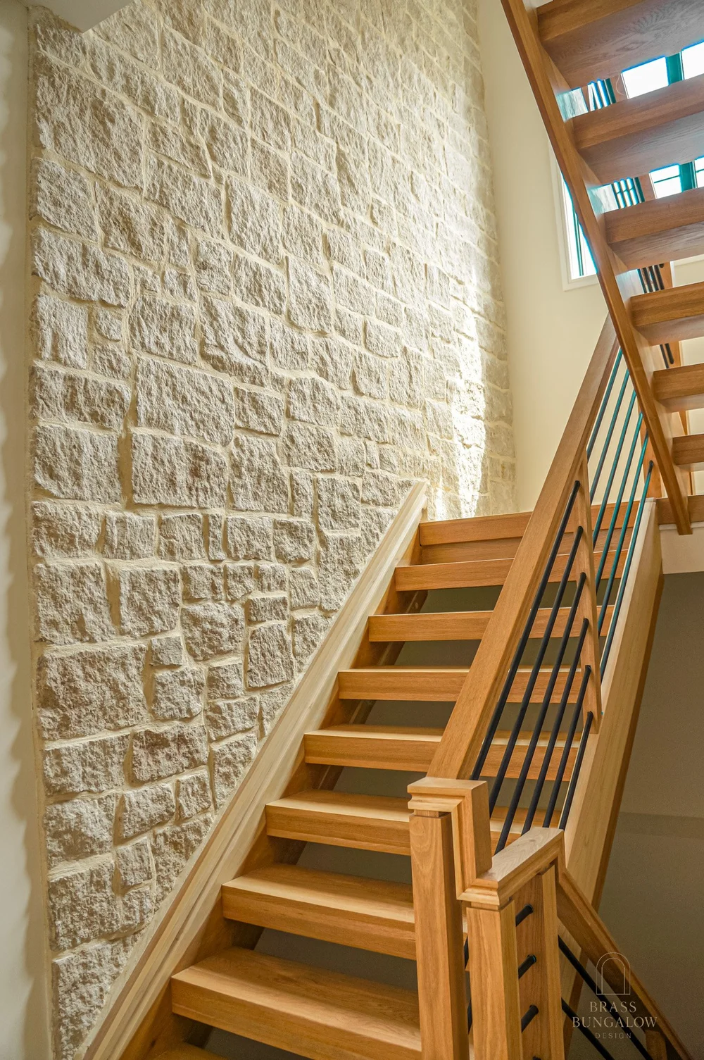 Wood staircase alongside a textured stone wall