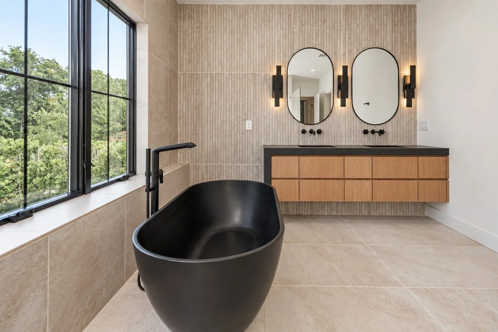 Primary bath with warm wood and layered finishes