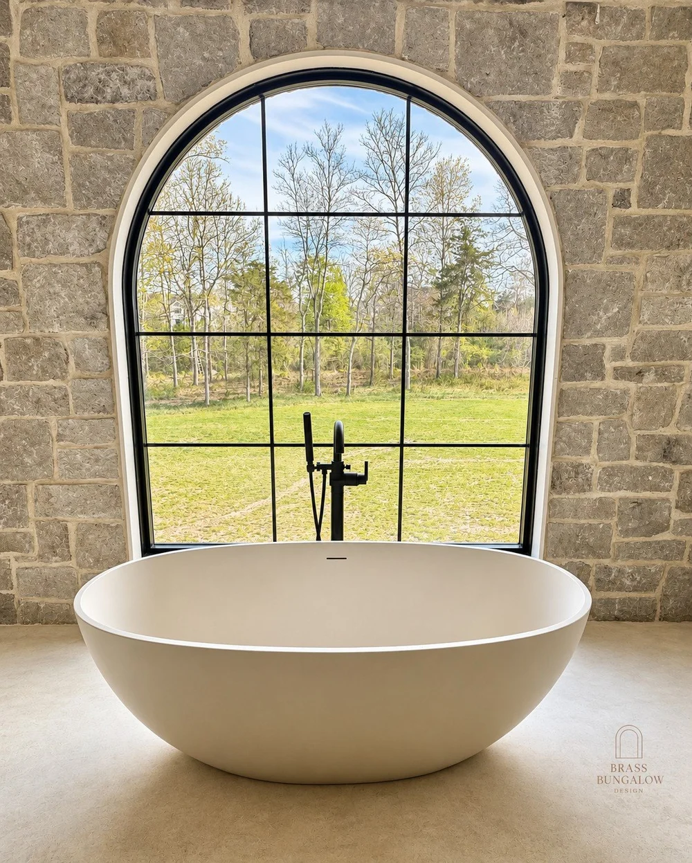 Primary bath with a freestanding tub and arched window