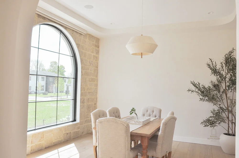 Dining space framed by natural stone and an arched window
