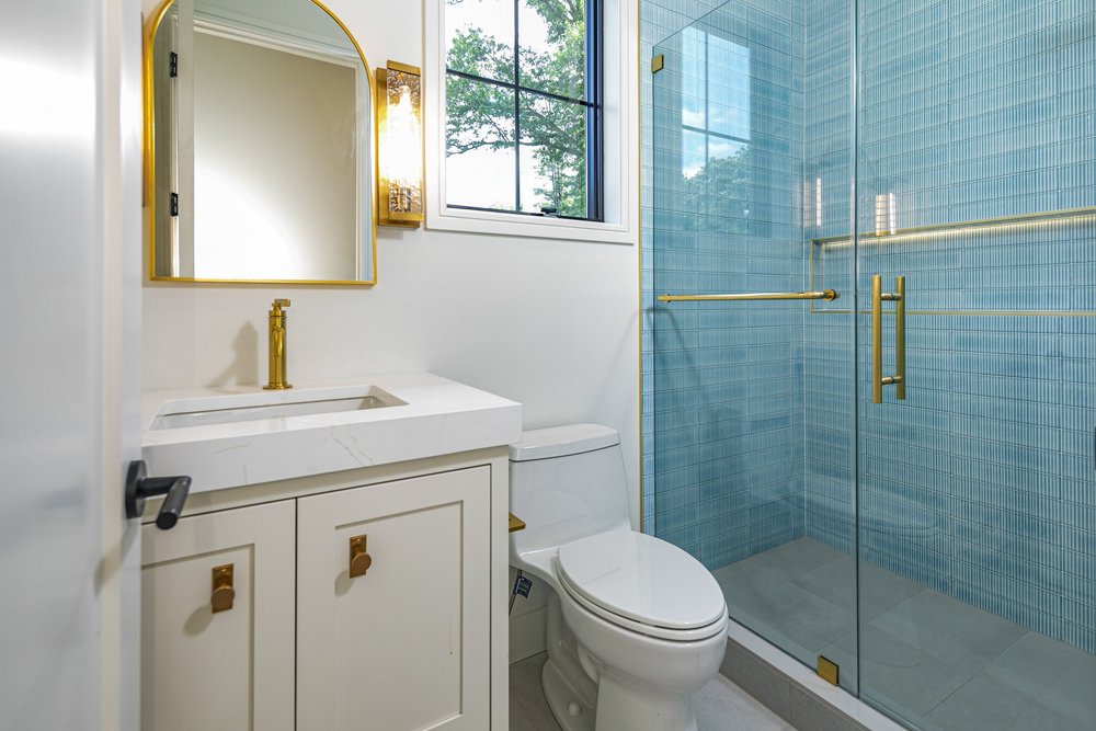 Bathroom with blue tile and brass accents
