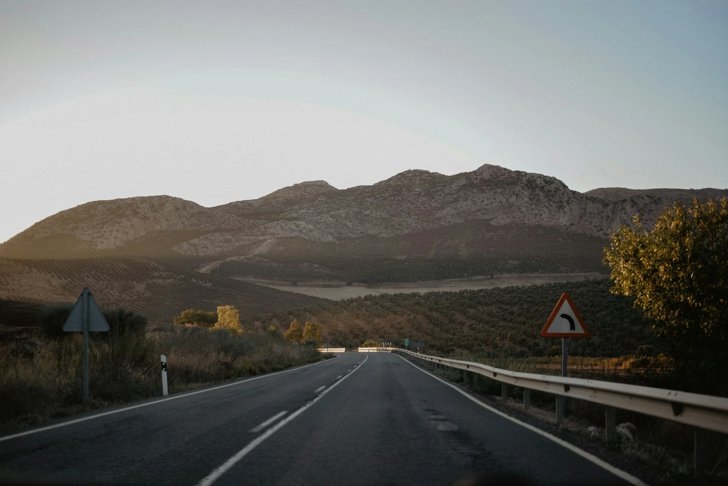 Open road through the mountains of southern Spain with warning signs