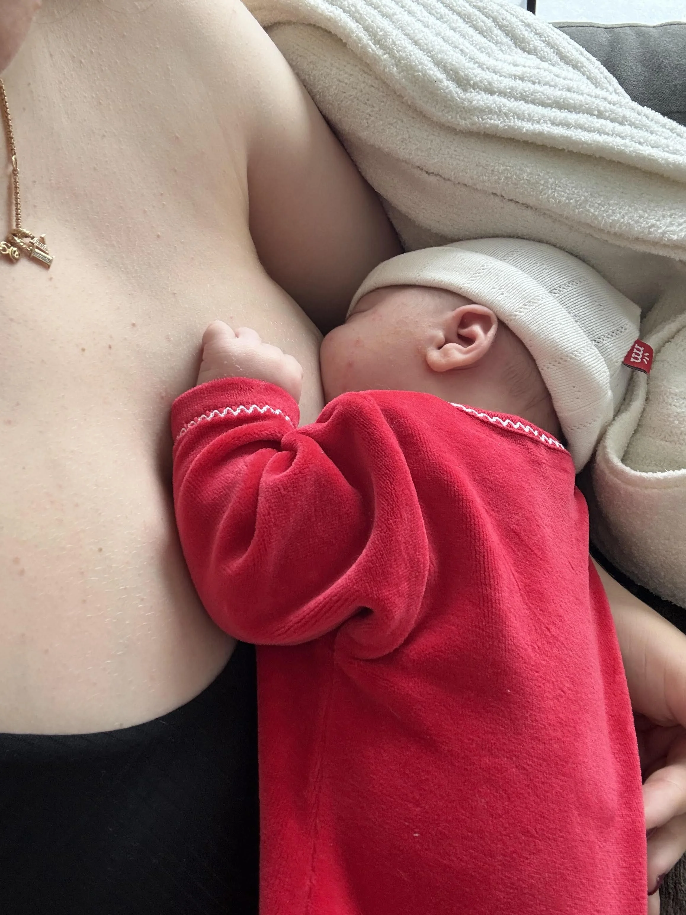 New mother breastfeeding baby with support from a birth doula.