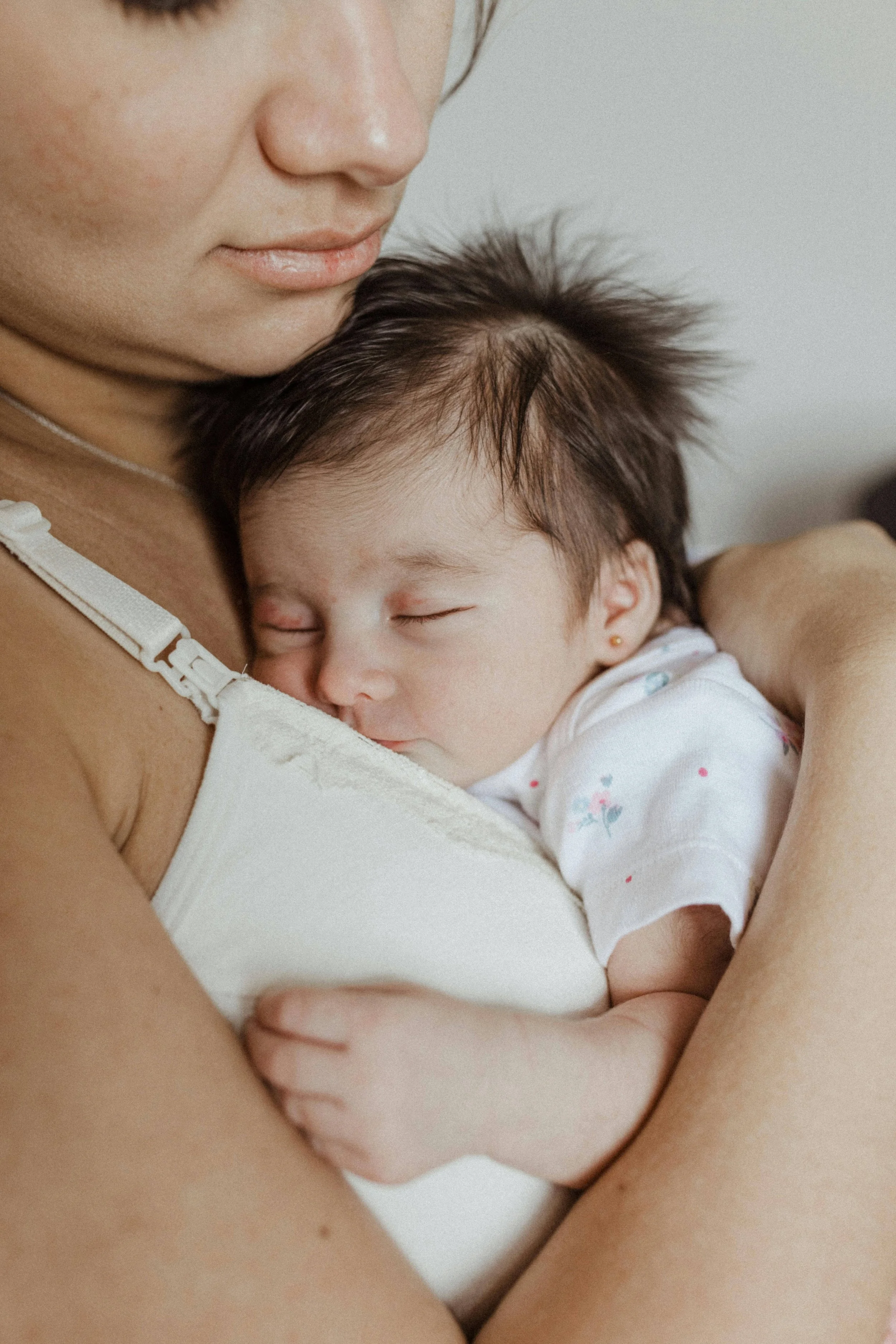 A mother holds her baby after a virtual sleep coaching session with Rachel Bernhard.