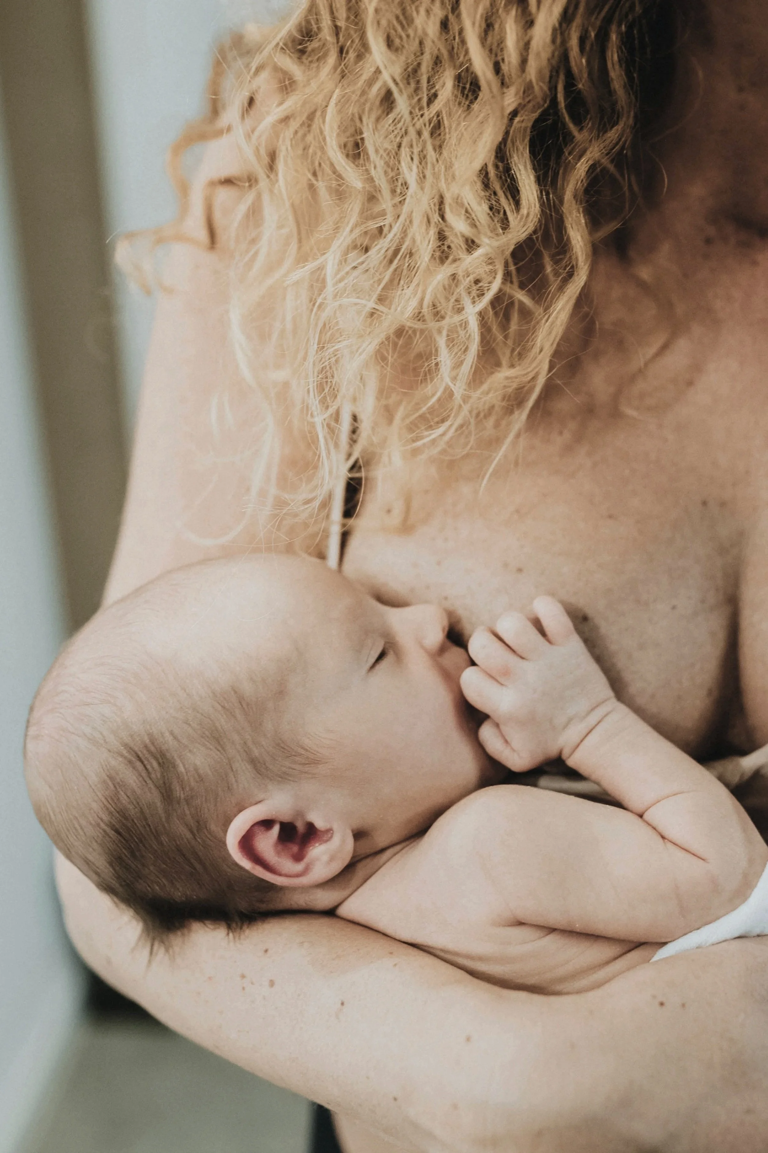 A mother nurses her newborn with the help of Rachel Bernhard's virtual 1:1 breastfeeding support.