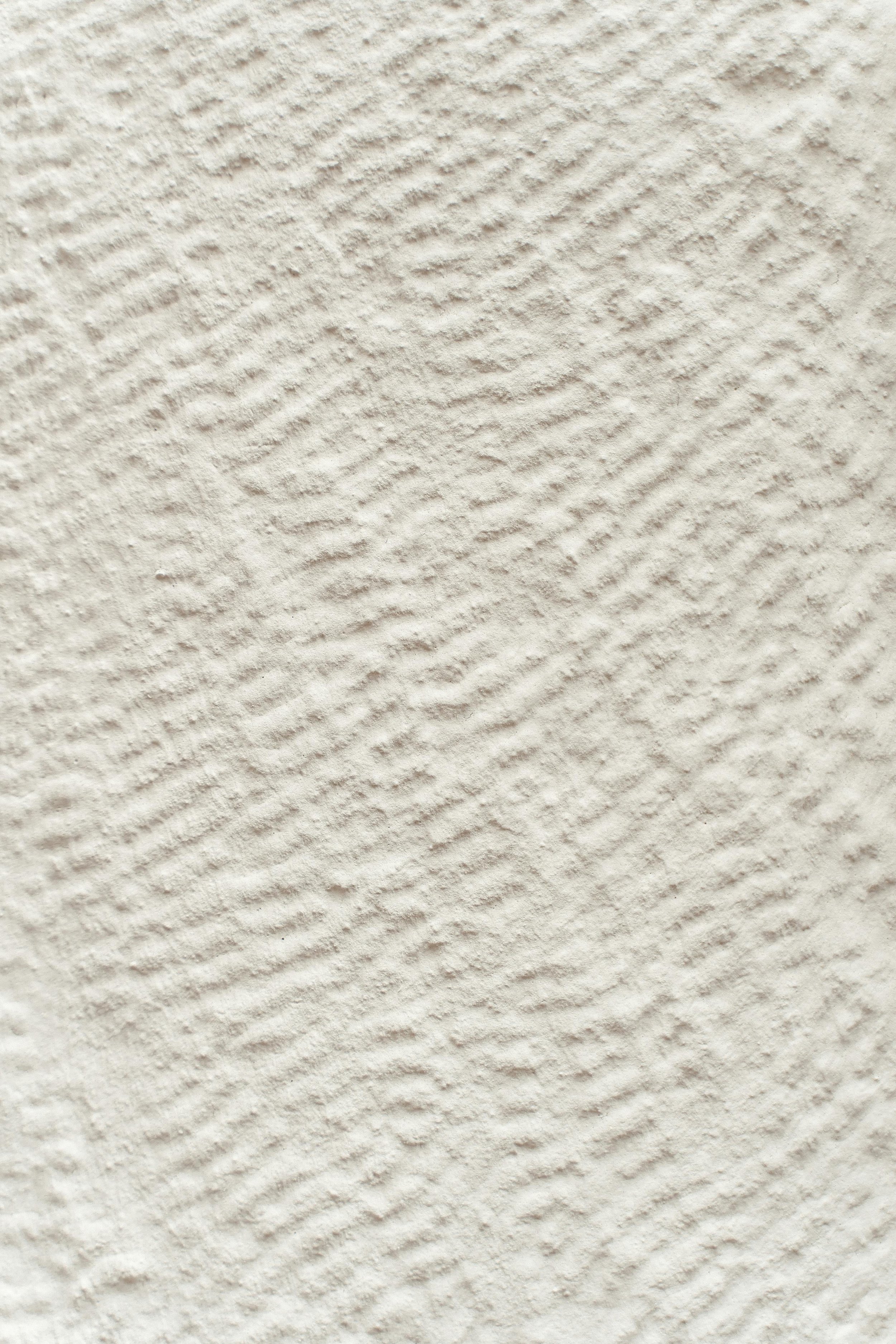 Close-up of textured off-white wall with diagonal ridges.