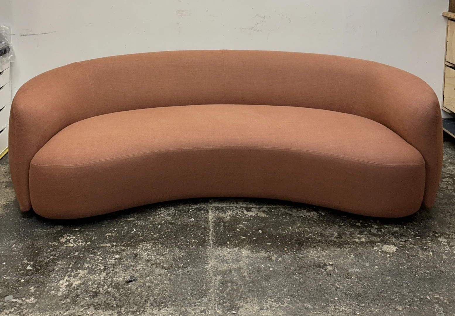 Curved sofa upholstery in Schumacher Fabrics terracotta linen