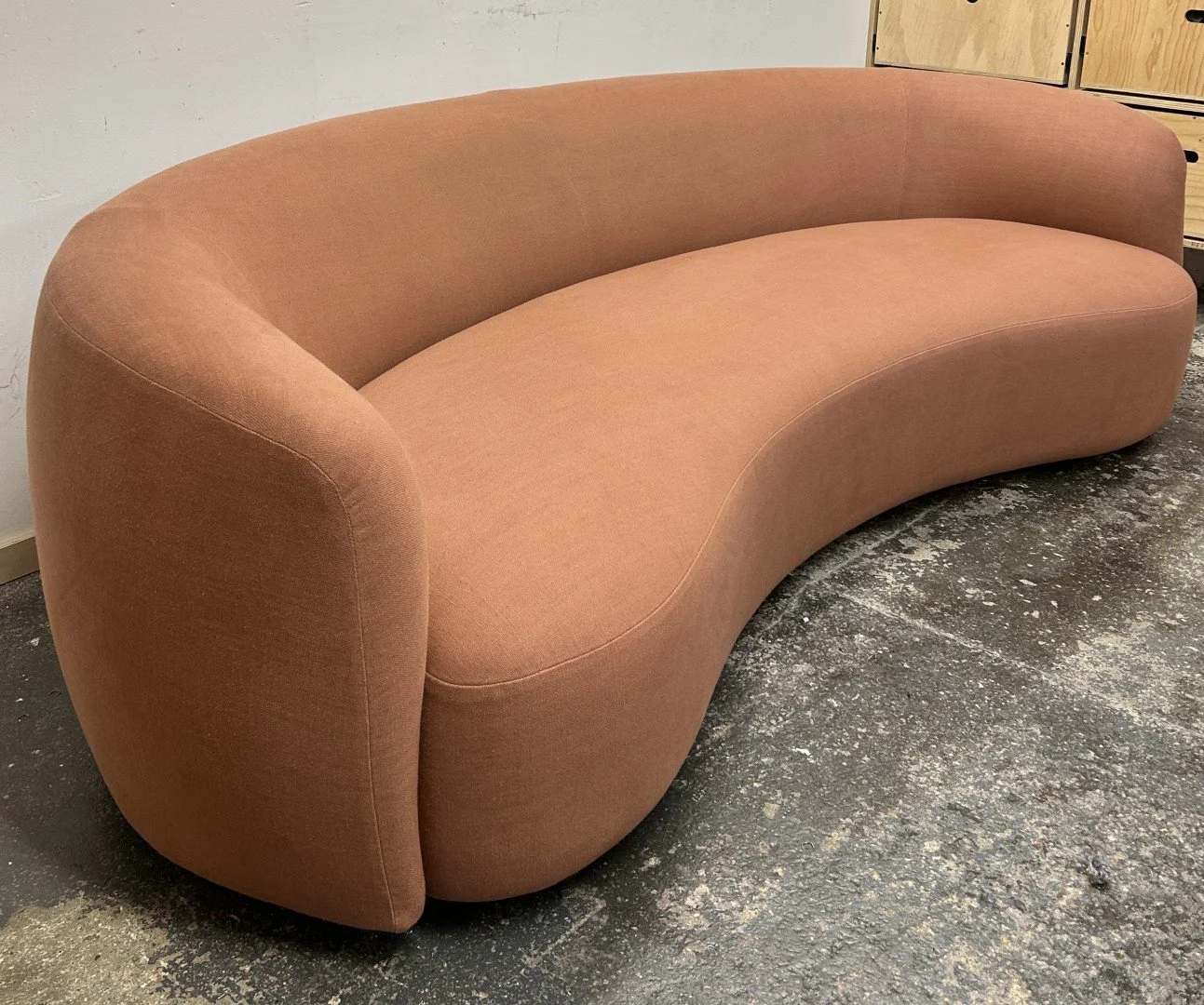 Curved sofa upholstery in Schumacher Fabrics terracotta linen