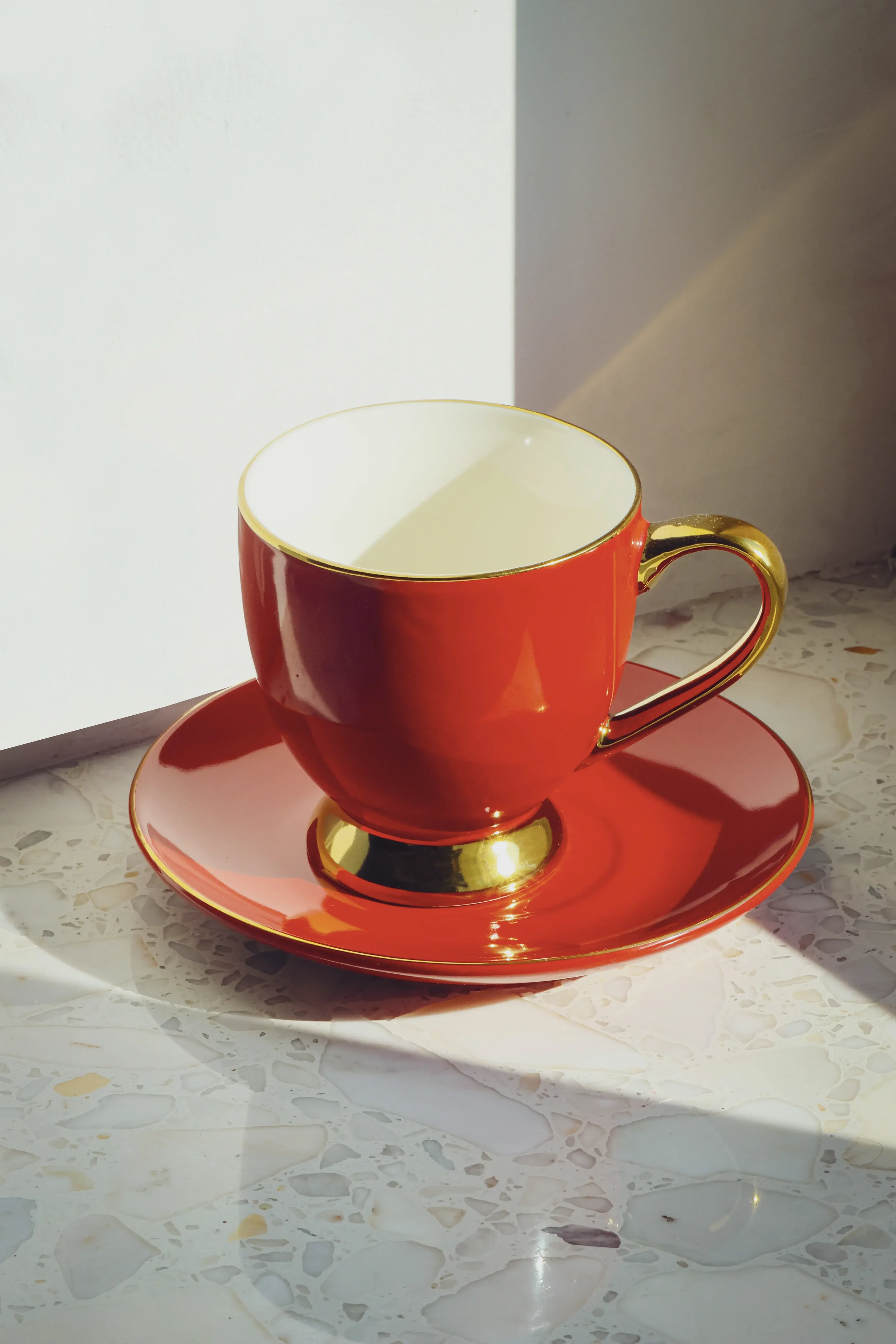 Red teacup on a terrazzo surface in natural light