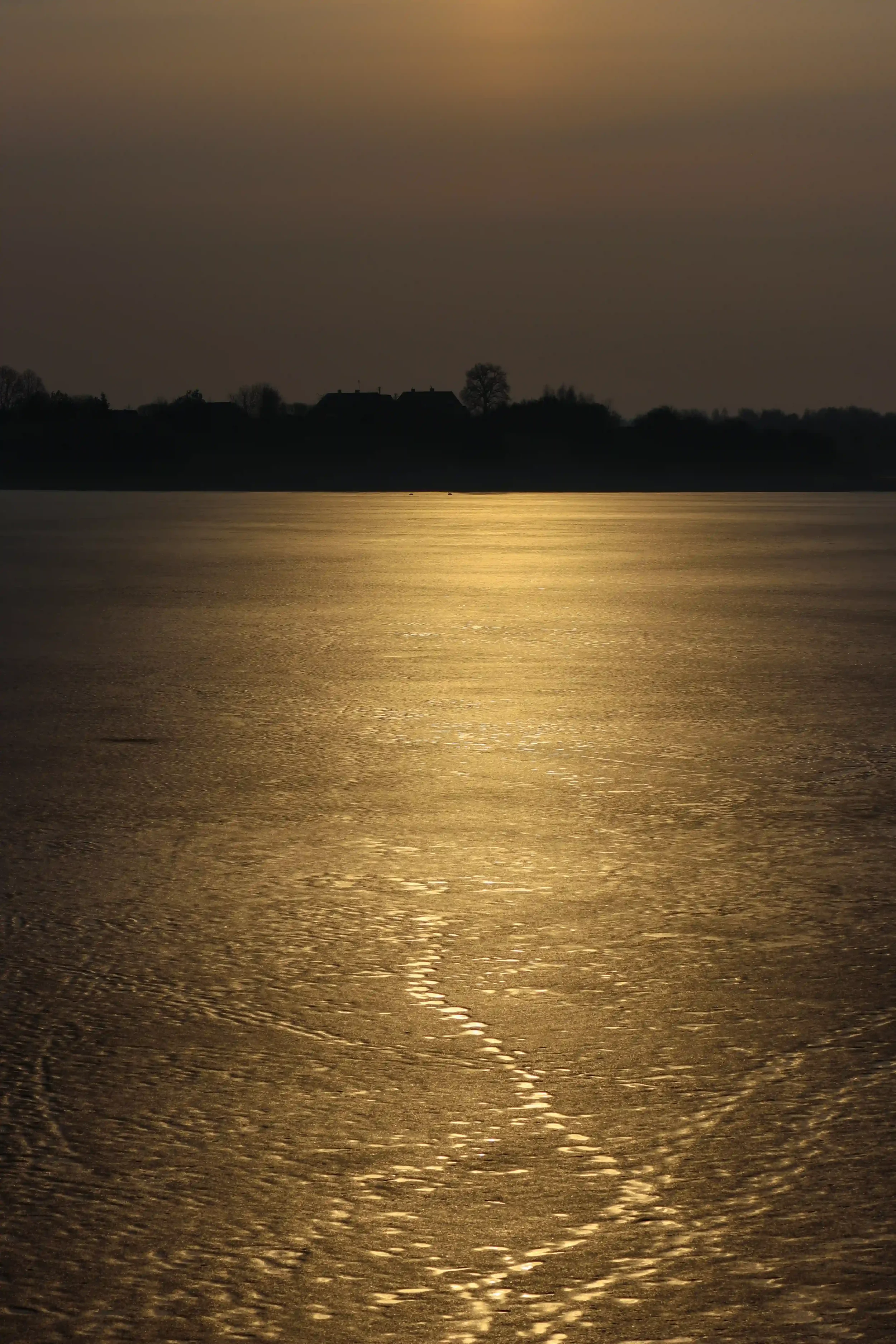 Frozen lake with golden light reflecting on the ice