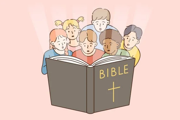 A group of children looking at a large Bible with a cross on the cover.
