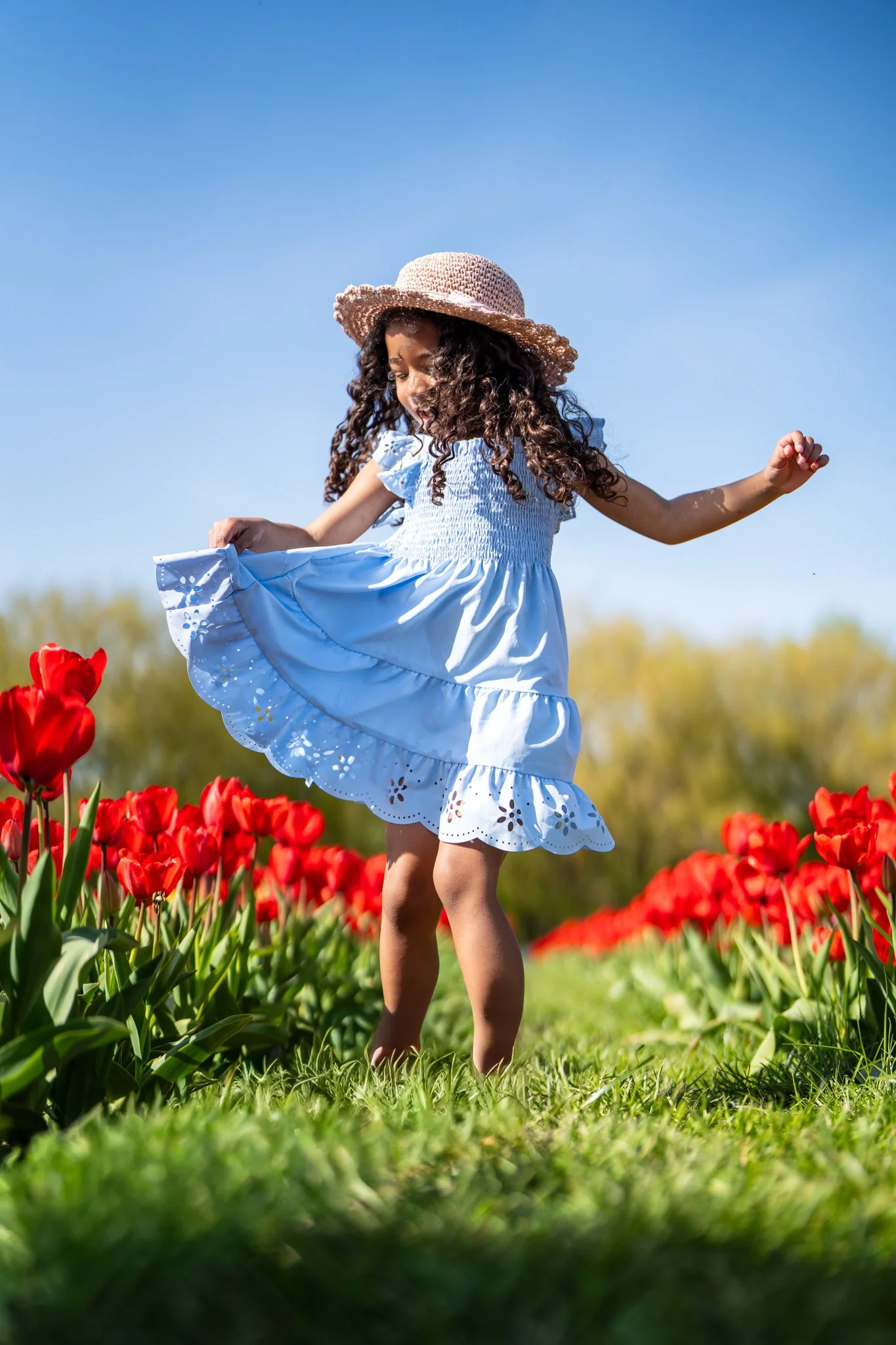 little girl dancing in red tulip field