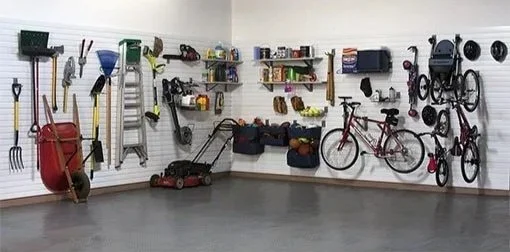 Organized garage wall with various tools, gardening equipment, and bicycles on display.