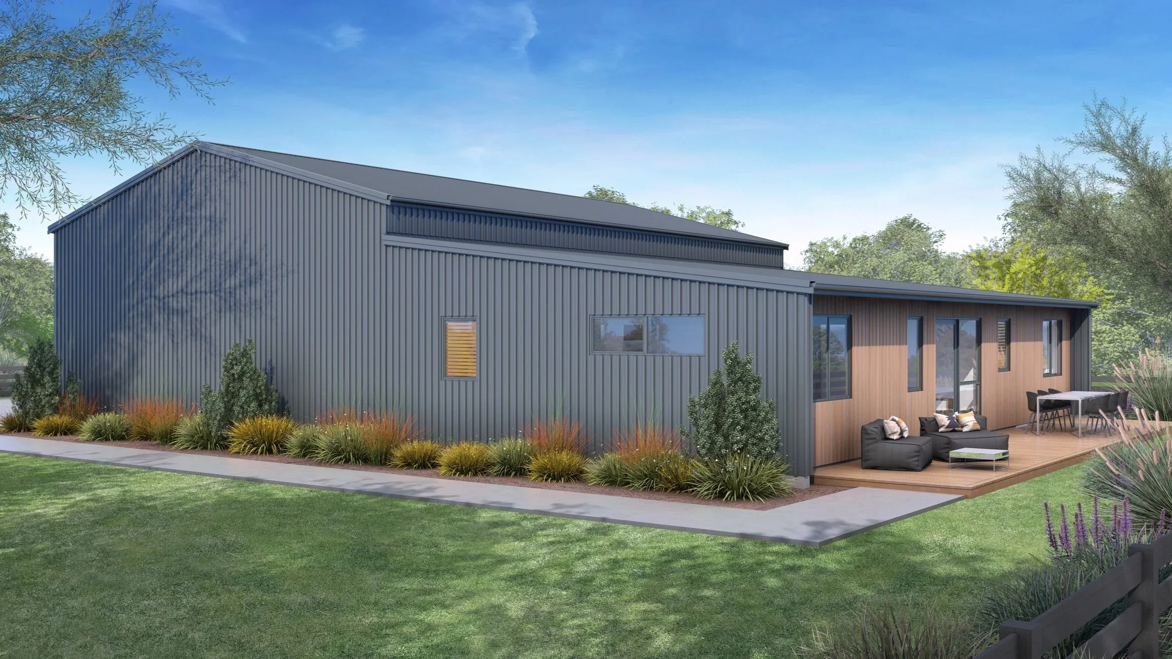 A modern building with metal siding and a wooden deck, surrounded by shrubbery and trees, with a lawn and a clear blue sky in the background.