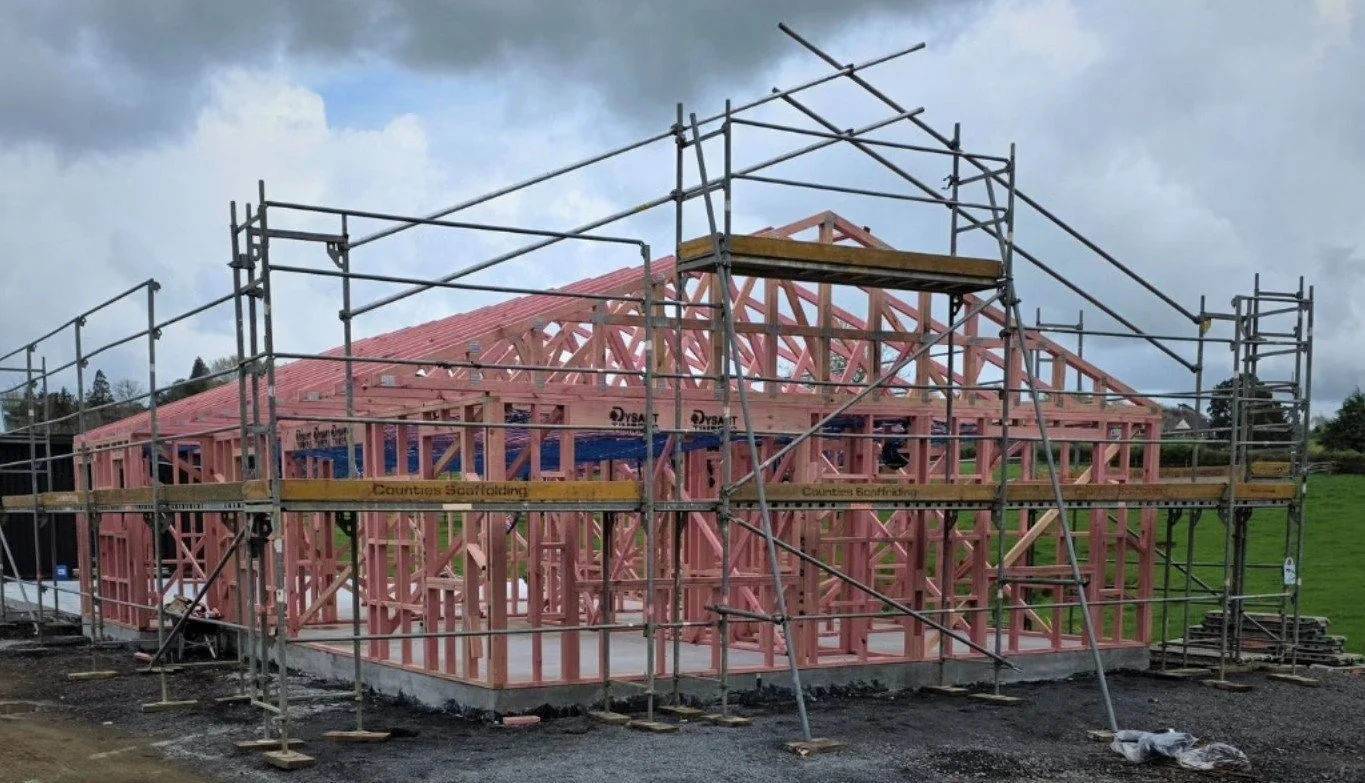 Construction site with a wooden house frame and scaffolding.