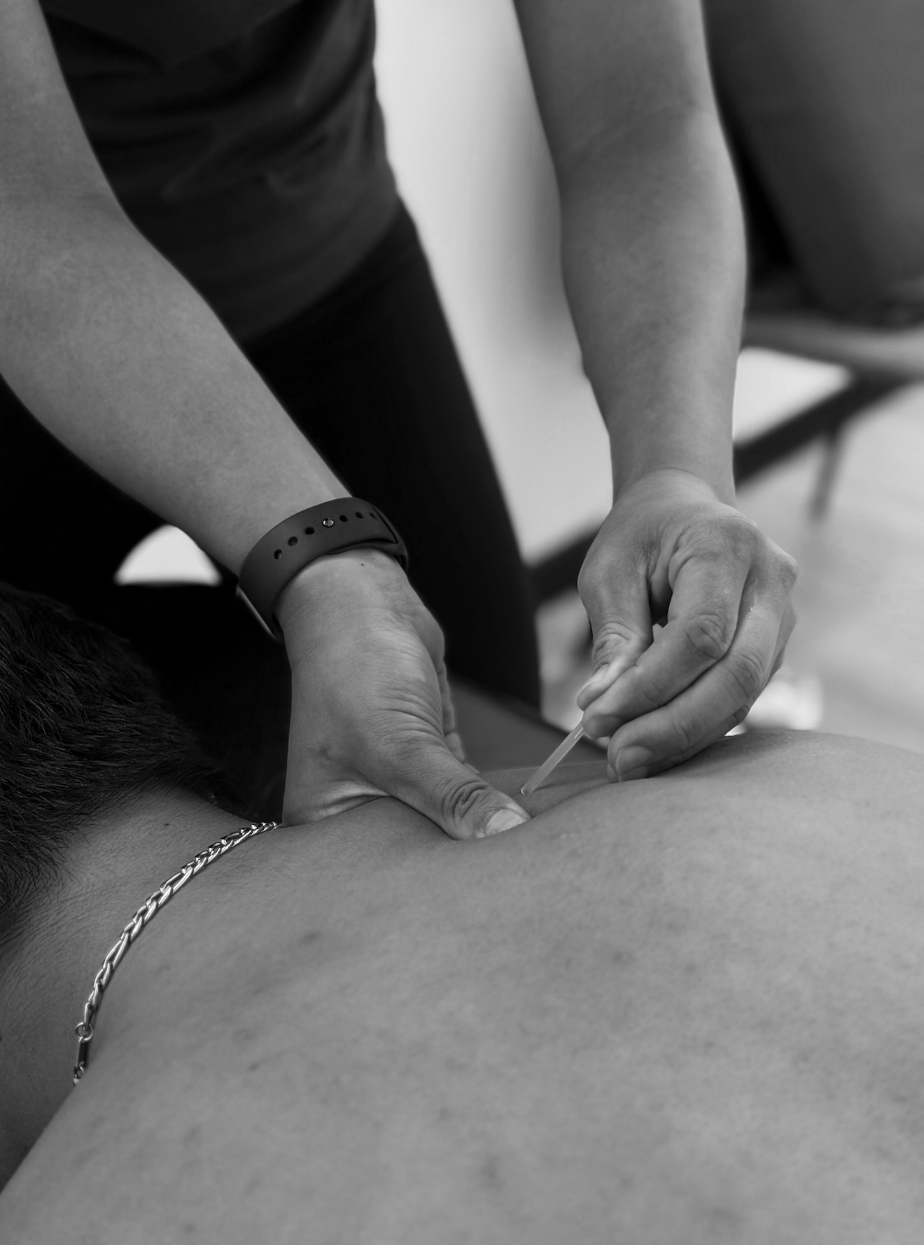 A person giving an injection or vaccination to another person lying down, in black and white.