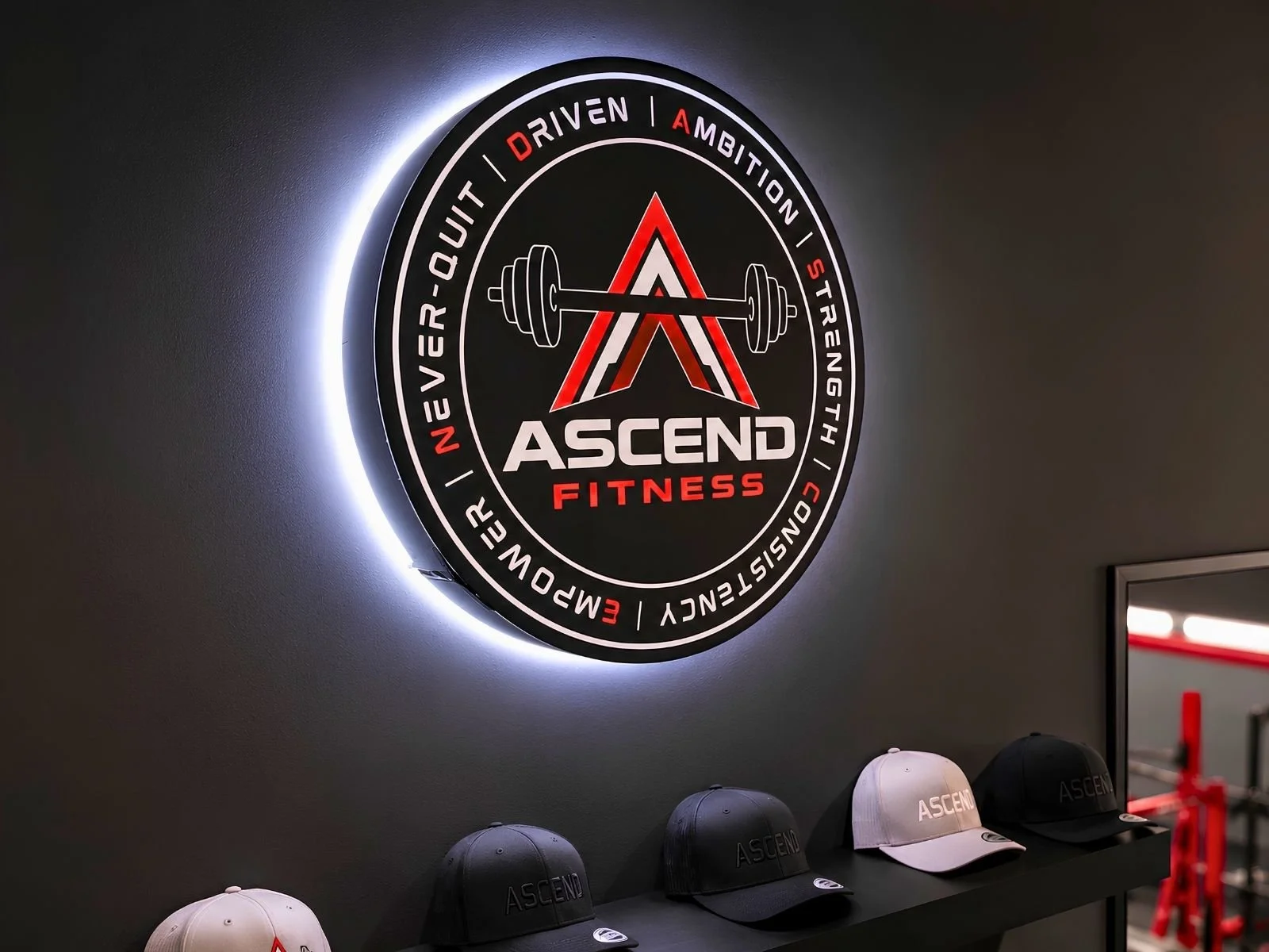 Illuminated Ascend Fitness logo displayed on an interior wall.