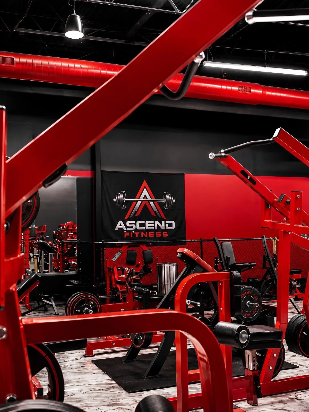 Interior of a red fitness gym with various workout equipment, a black and red