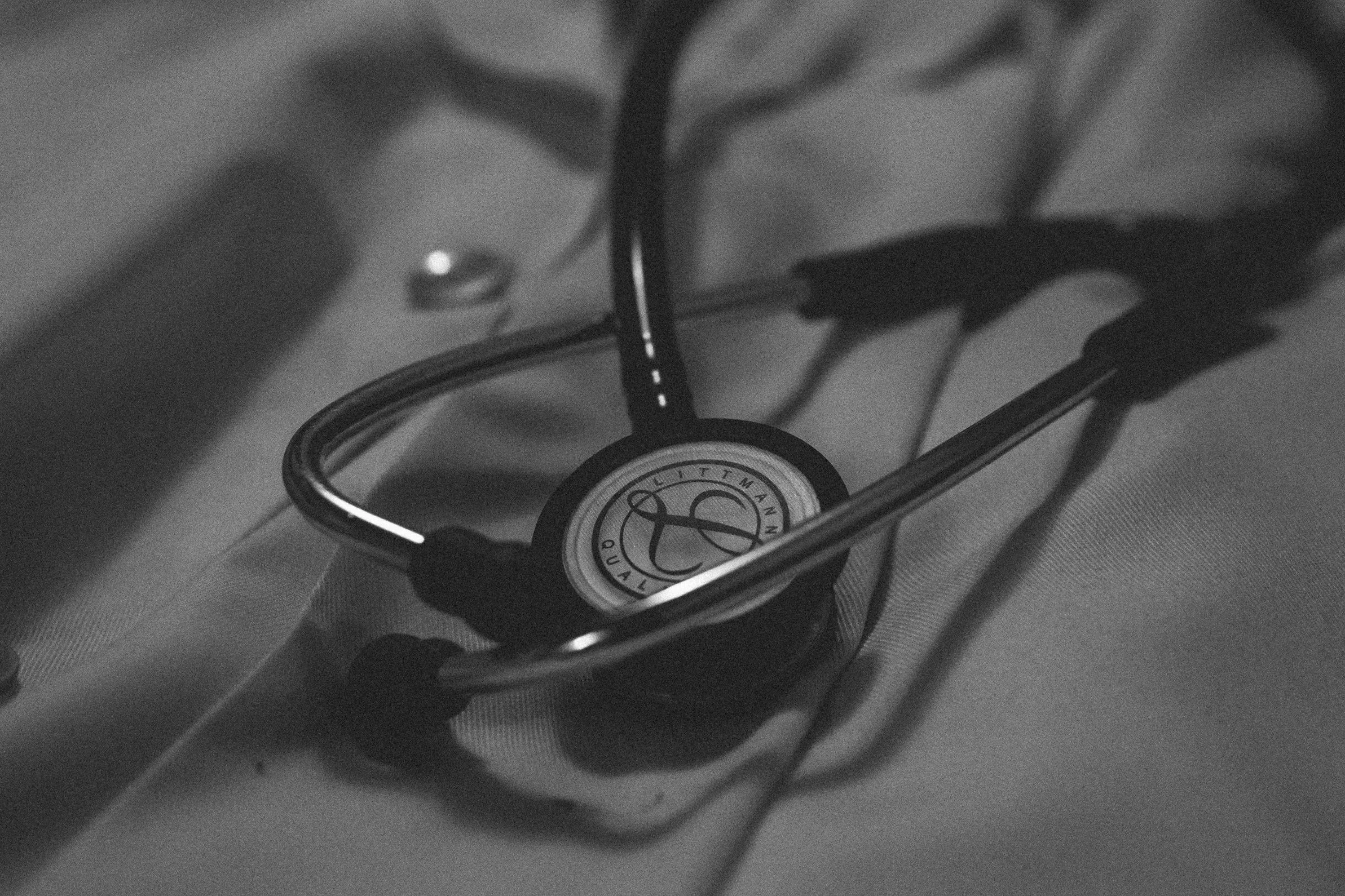 A black and white photo of a stethoscope resting on a metal grate.