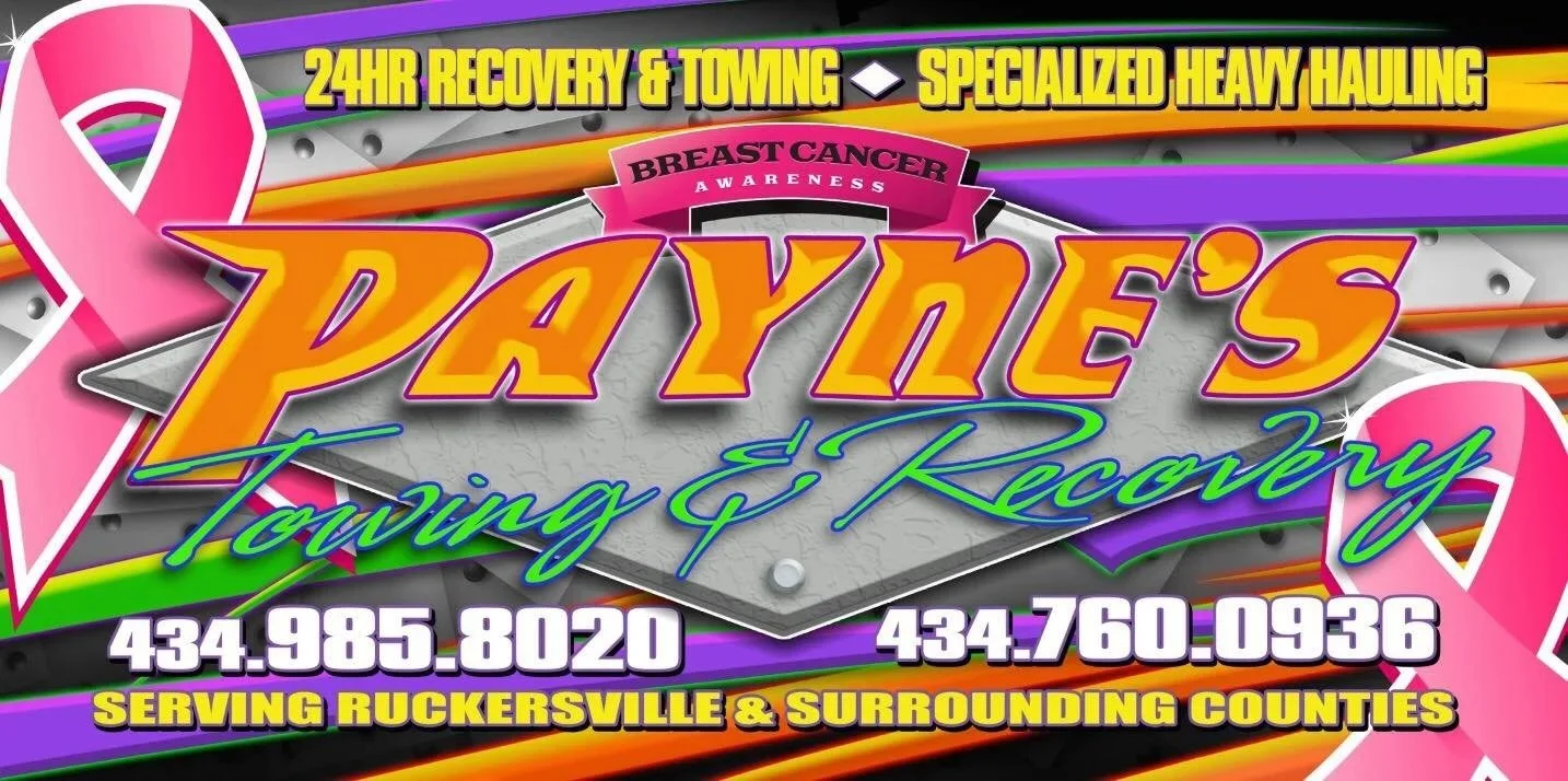 A colorful sign advertising a towing and recovery service with breast cancer awareness ribbons, phone numbers, and service area details.