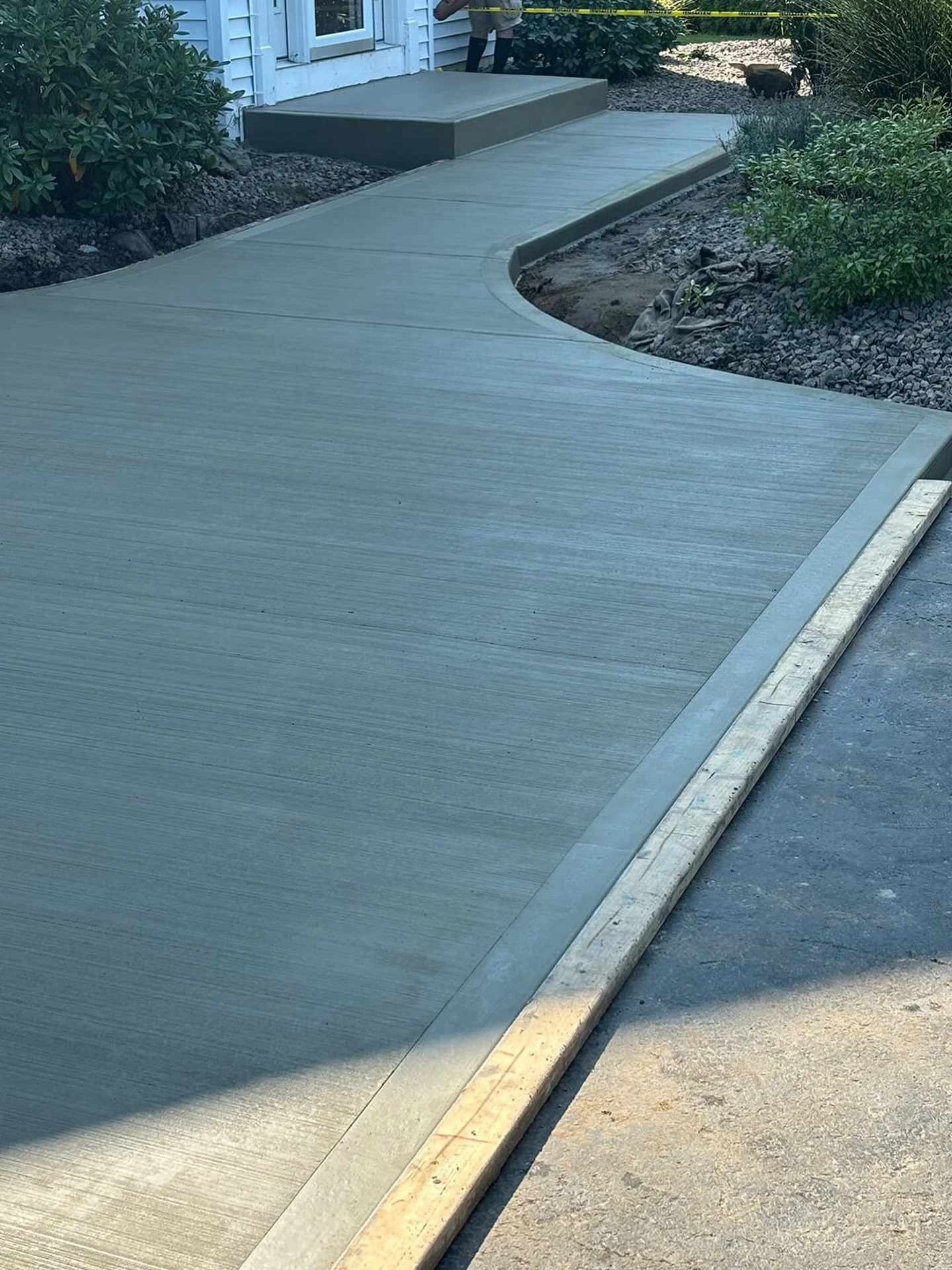 Curved concrete walkway with a clean broom finish and trowel finished edges.

Nice flow into the entry with smooth edges and solid prep, built to last and keep things looking sharp.

If you&rsquo;re looking to upgrade your walkway or concrete around 