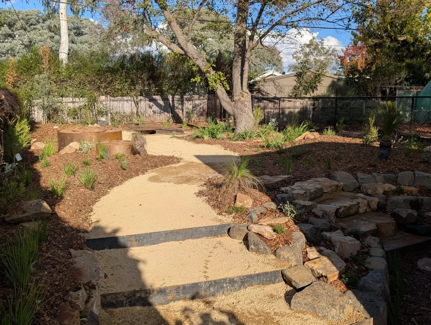Our clients wanted a different approach to this design. 

 As soon as you enter the backyard you are drawn to the winding granite path that leads to the fire pit area. 
The thing that makes this yard unique is most of the materials are recycled. 

Th