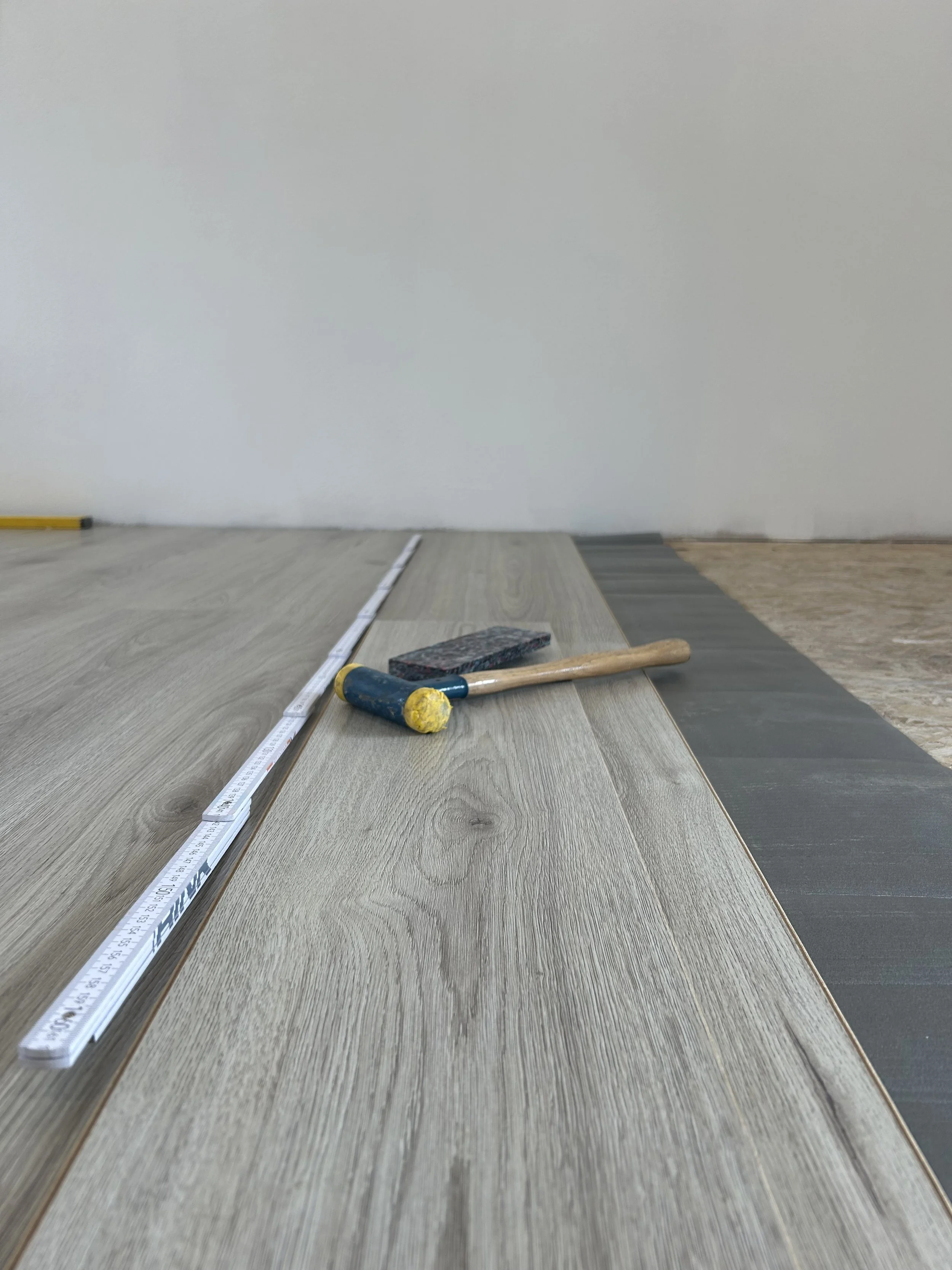 Flooring samples with a ruler and tools for installation.