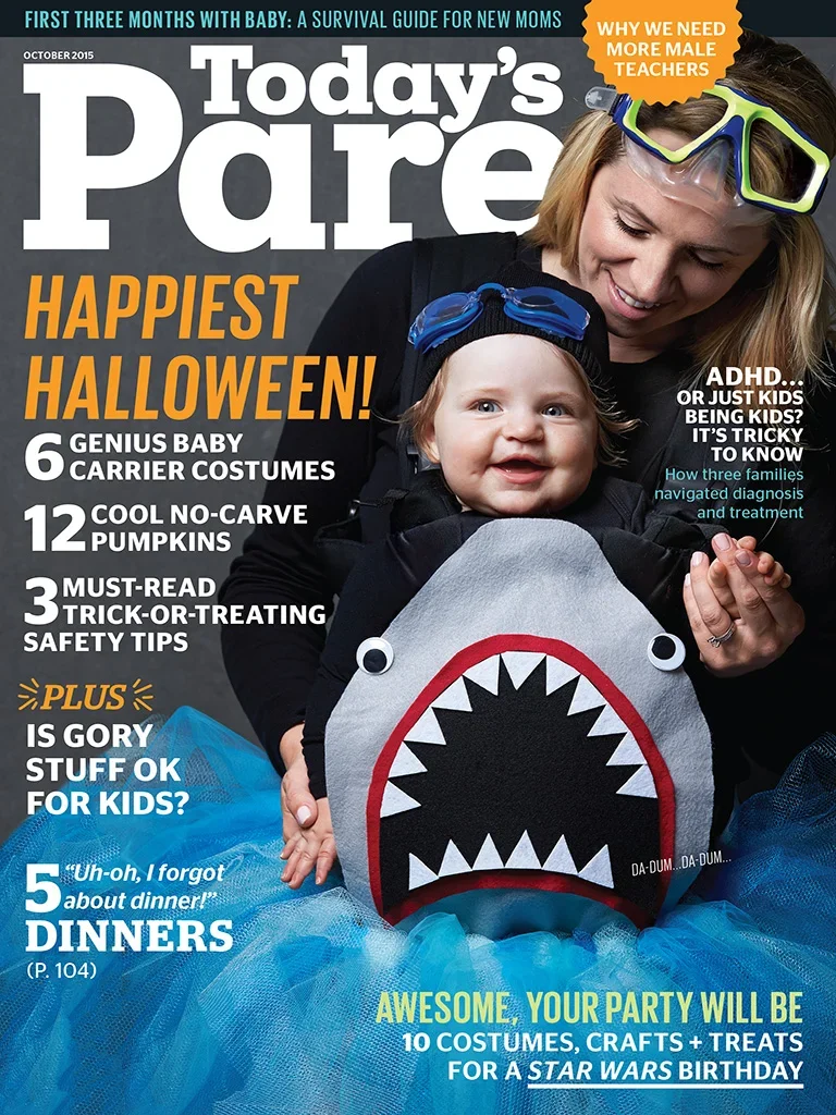 Today's Parent magazine cover prop styled by rayna marlee A smiling woman and a baby in a shark costume with a face and teeth, celebrating Halloween. The woman is wearing goggles on her head and holding the baby dressed in a shark-themed costume.