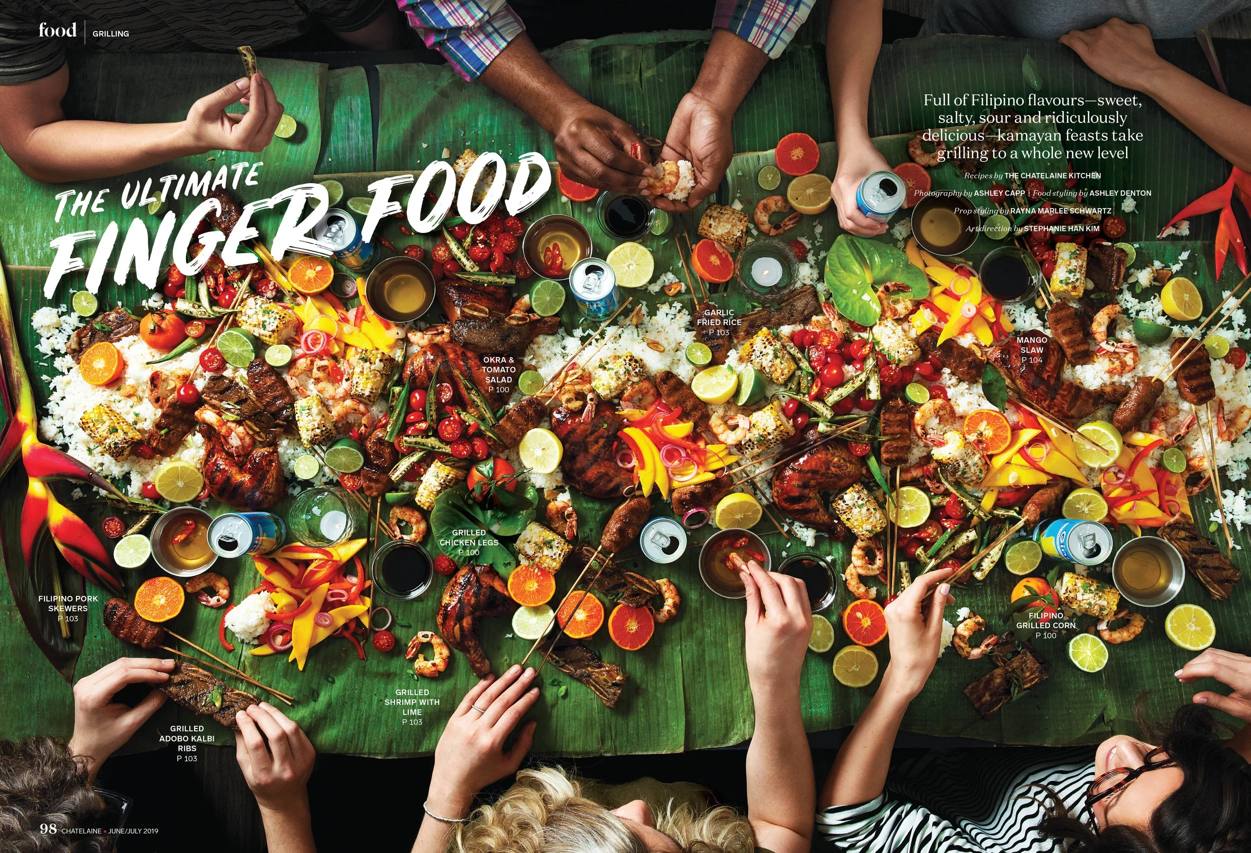Chatelaine A table filled with Filipino finger foods including grilled pork skewers, grilled chicken legs, grilled shrimp with lime, grilled adobo kalbi ribs, grilled corn, and various vegetables and fruits with multiple people reaching for the food.