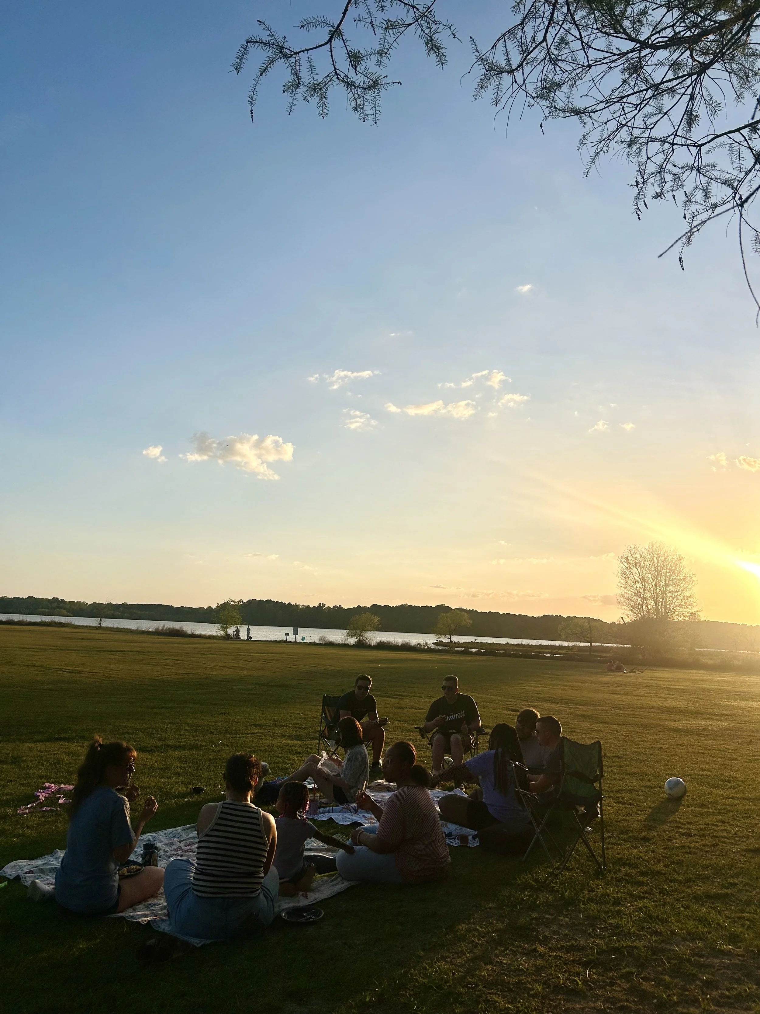 Picnic in a large open field at sunset.