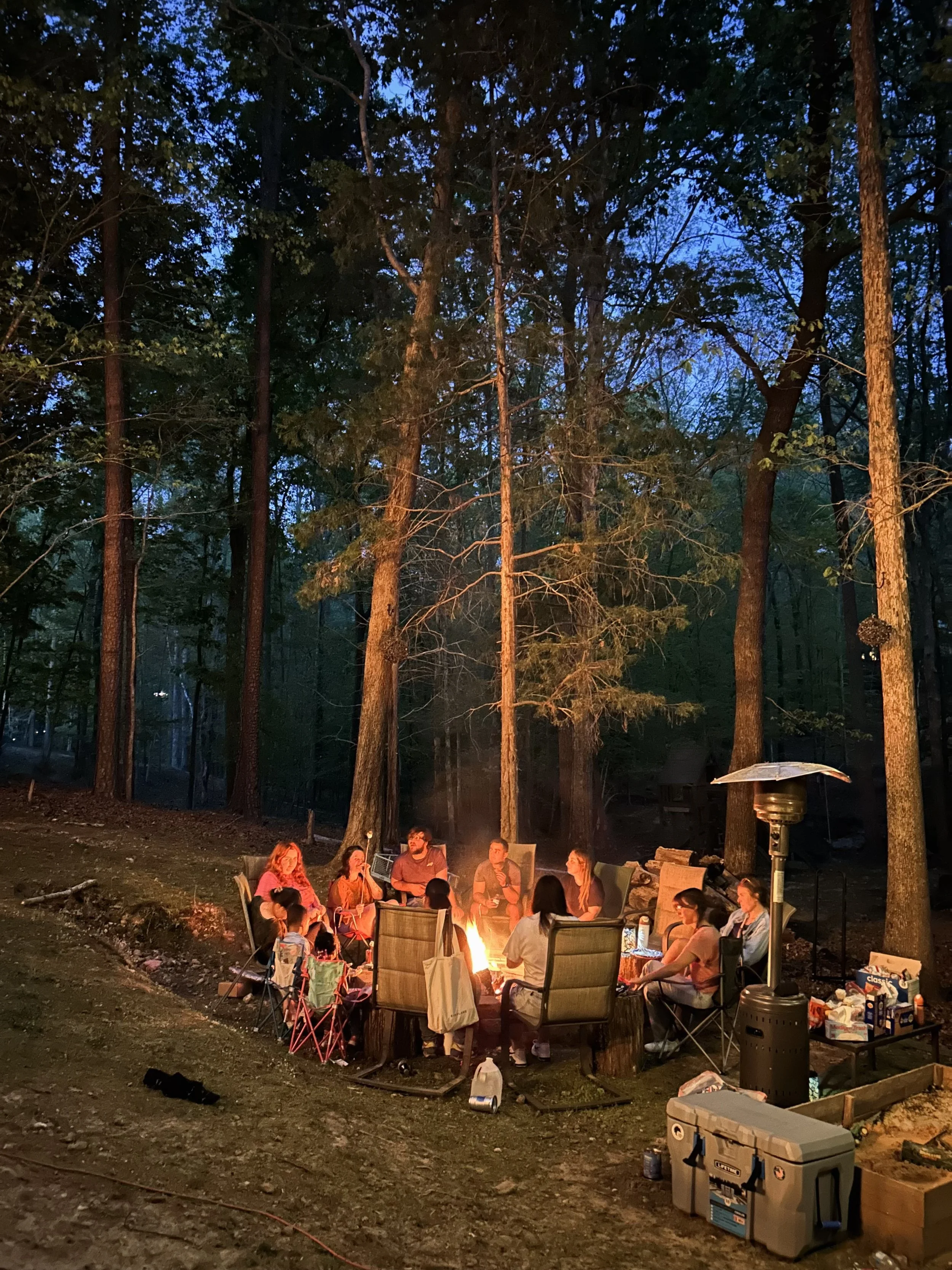 Everyone around a campfire at night.