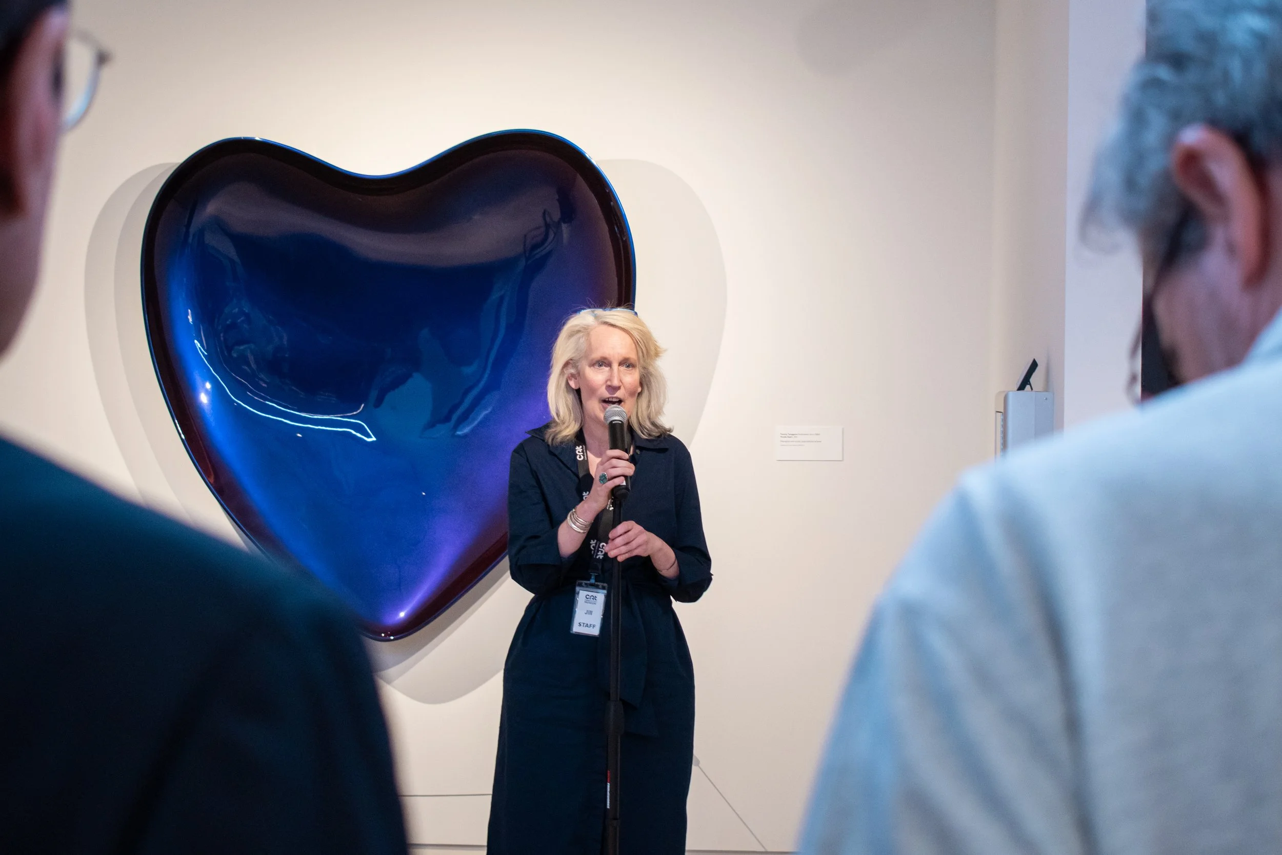 A museum curator speaking into a microphone.