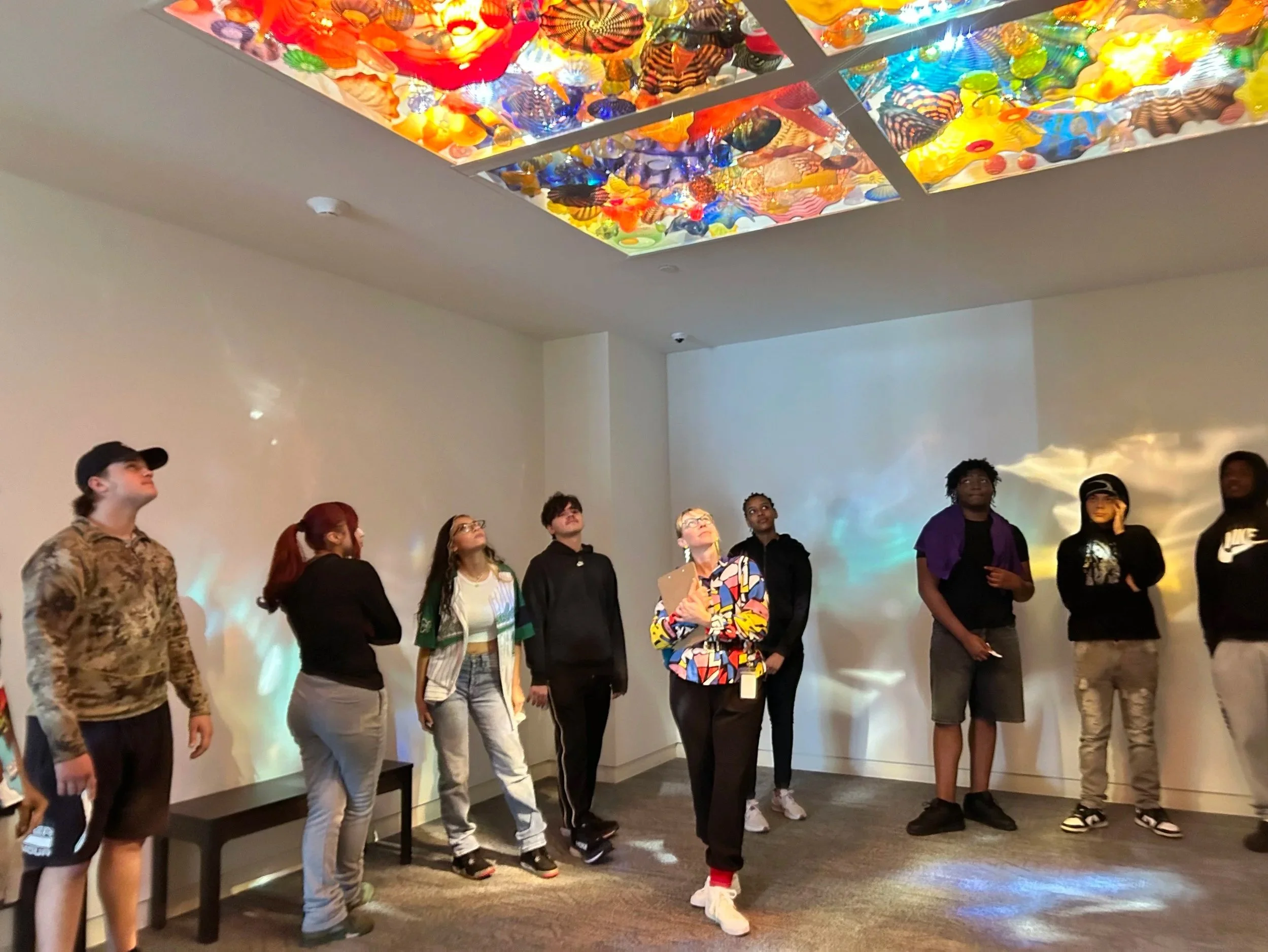 High school students and their teacher standing in the Pergola Room looking up at the ceiling. 