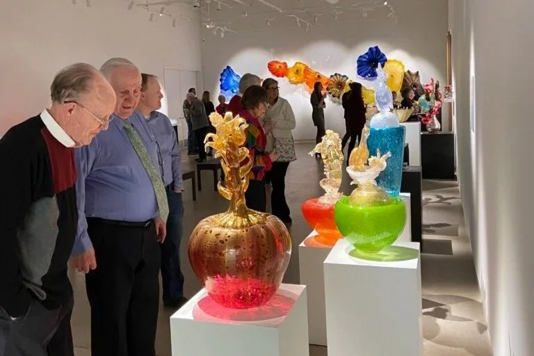 People look at Dale Chihuly's artwork in the gallery. 
