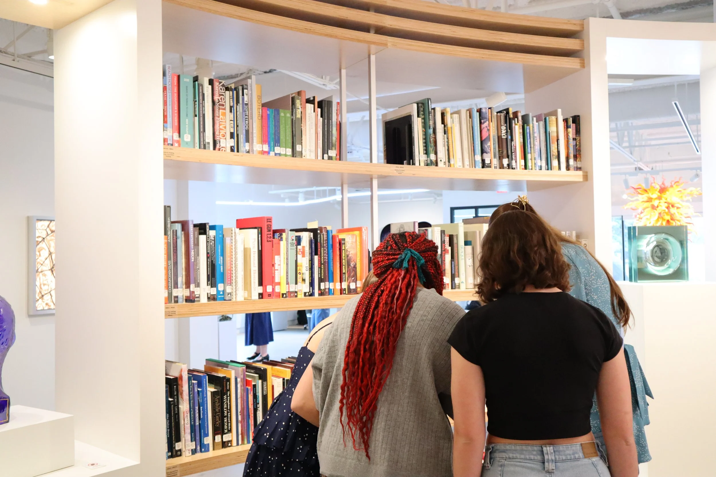 Teenagers gathered around a single focal point looking at something together.