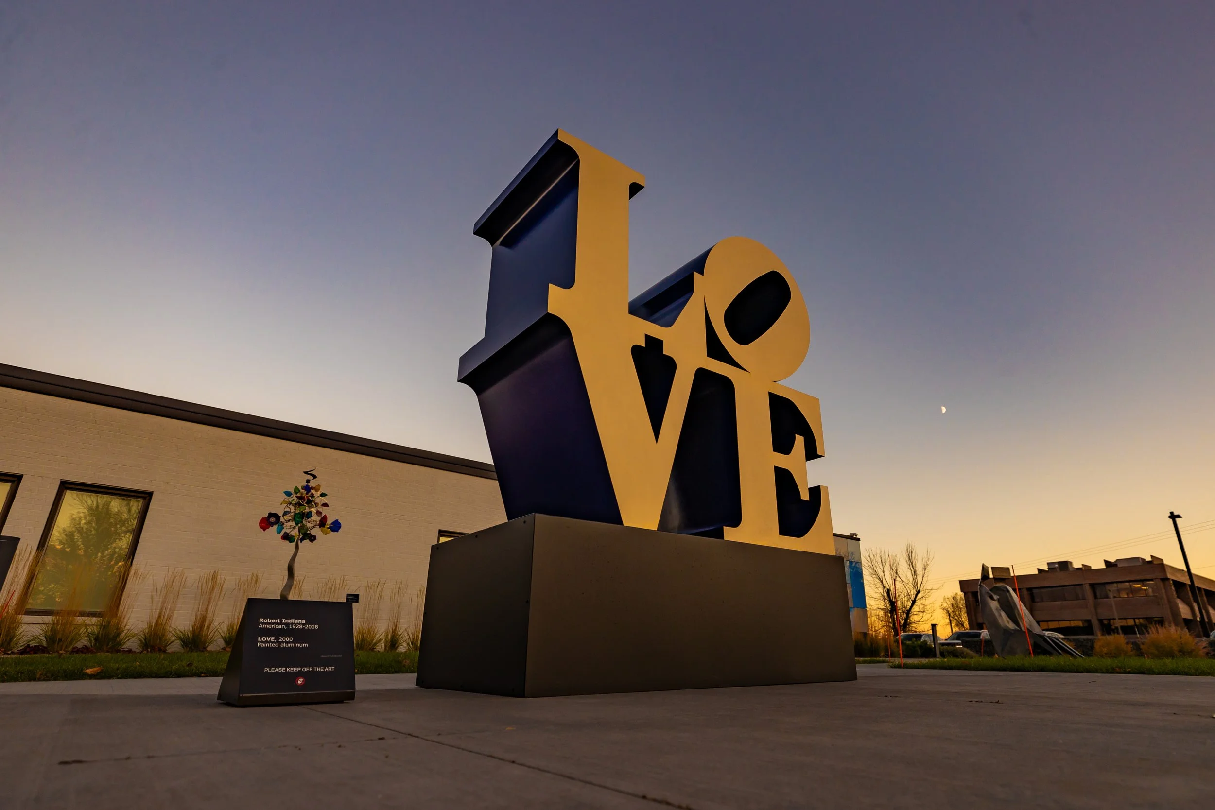 Robert Indiana's iconic LOVE sculpture against a darkening twilight sky.