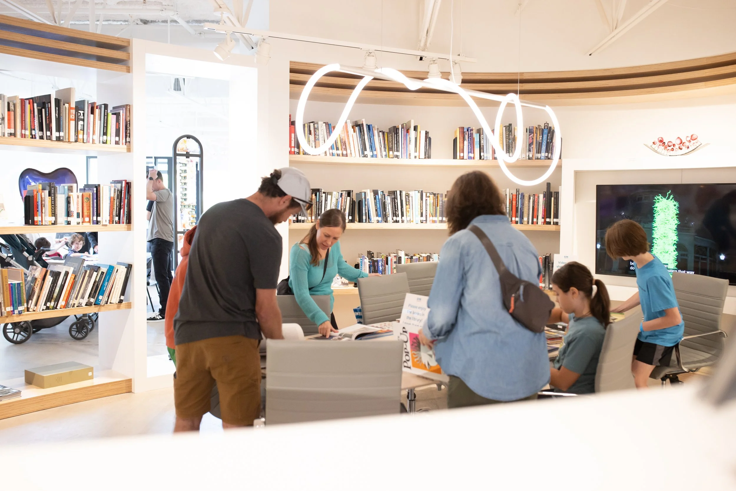 Families looking at books in the library.
