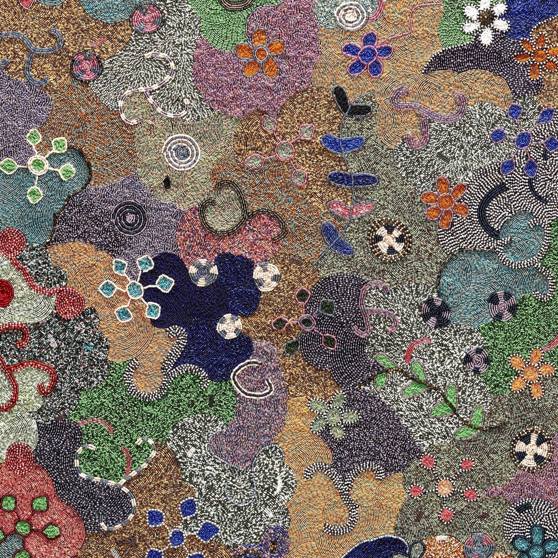 Artwork with beads of different colors and sizes arranged in a swirling abstract pattern.