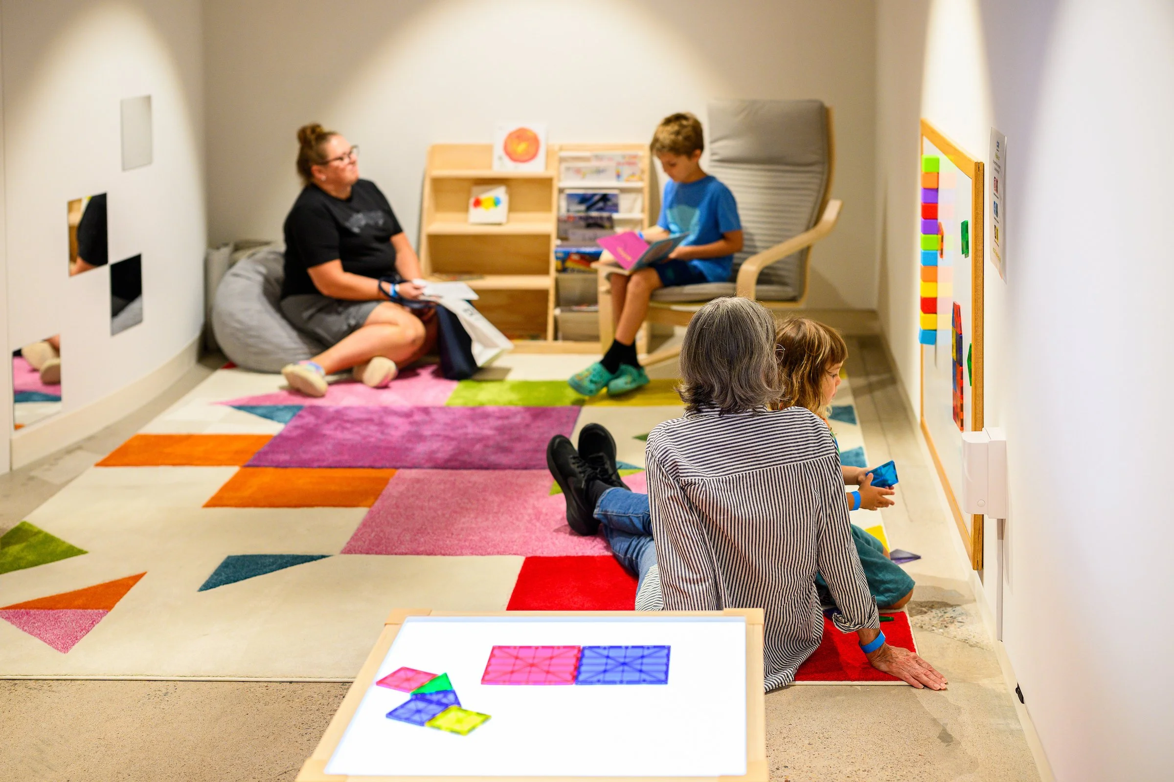Parents and children relaxing in the museum's cozy colorful Family Nook.