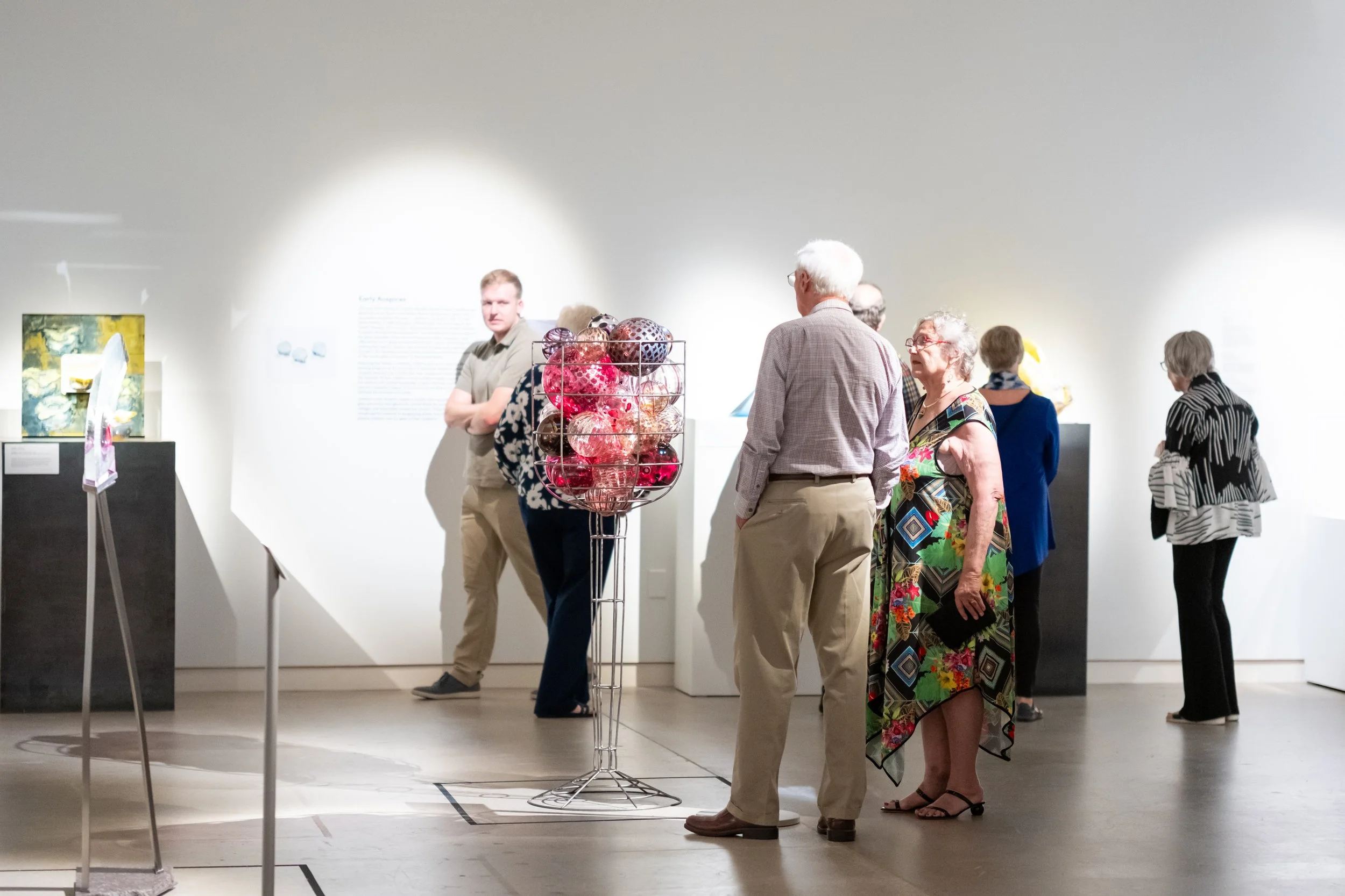 People look at art in the gallery. 